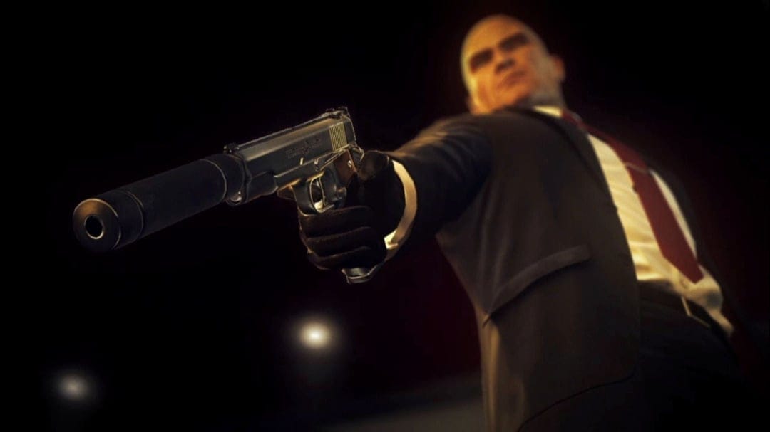 Agent 47 in a black suit aiming a silenced silver pistol forward under dramatic cinematic lighting.