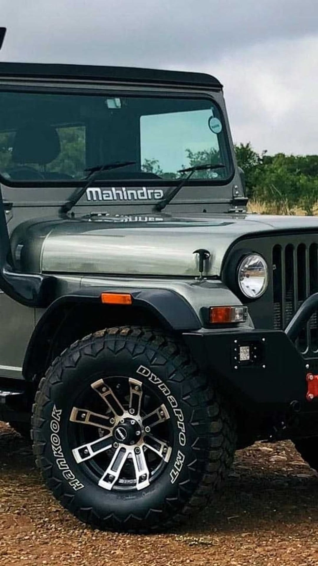 Mahindra Thar front tire with deep treads and black grille captured in a detailed vertical off-road composition.