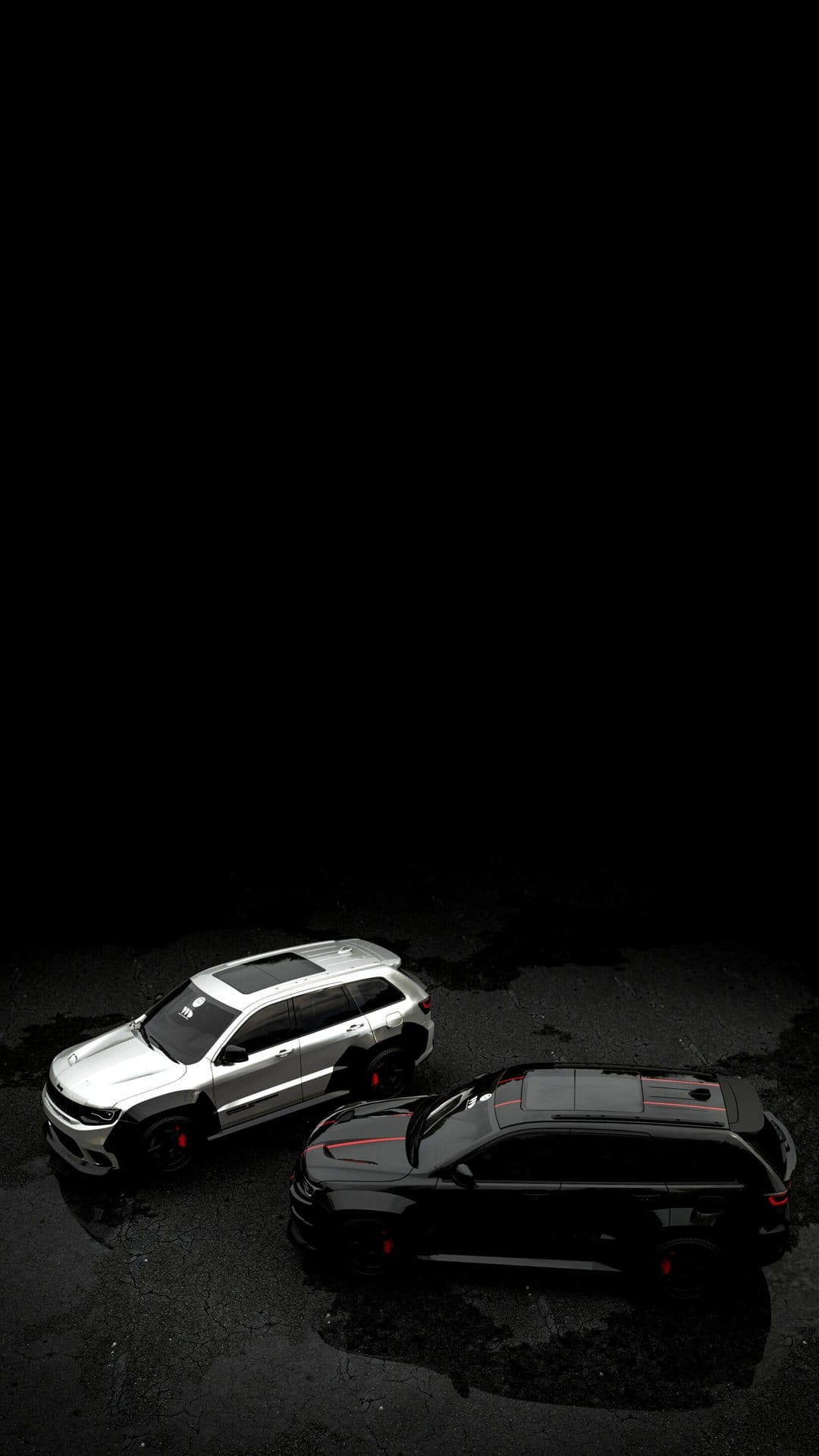 Silver and black SUVs parked on wet asphalt with mirror-like reflections under a dark, atmospheric sky.