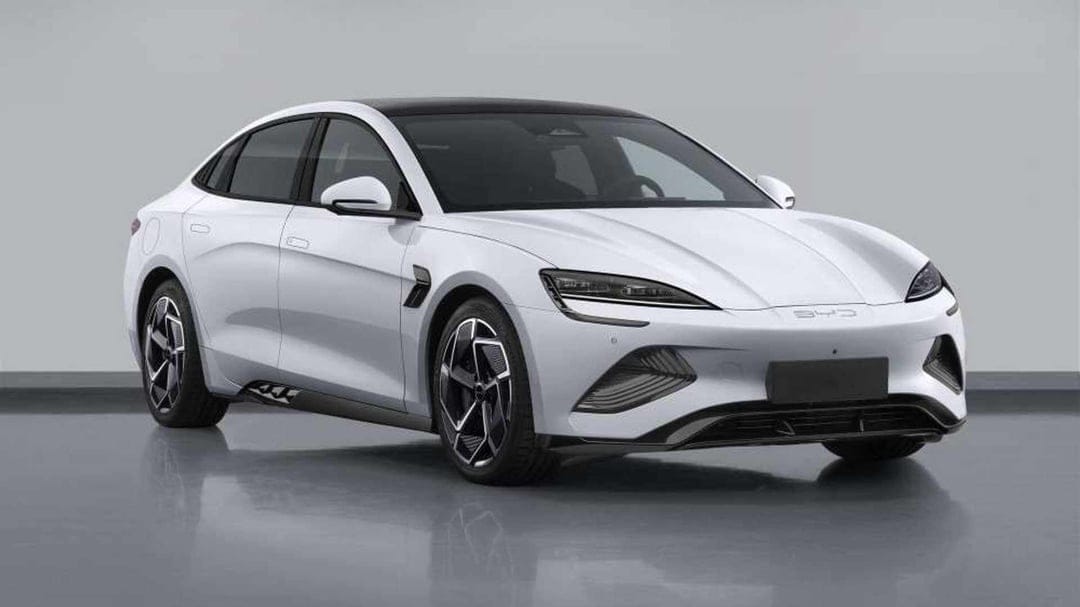 White BYD Seal electric sedan with black roof and alloy wheels in a neutral grey studio environment.