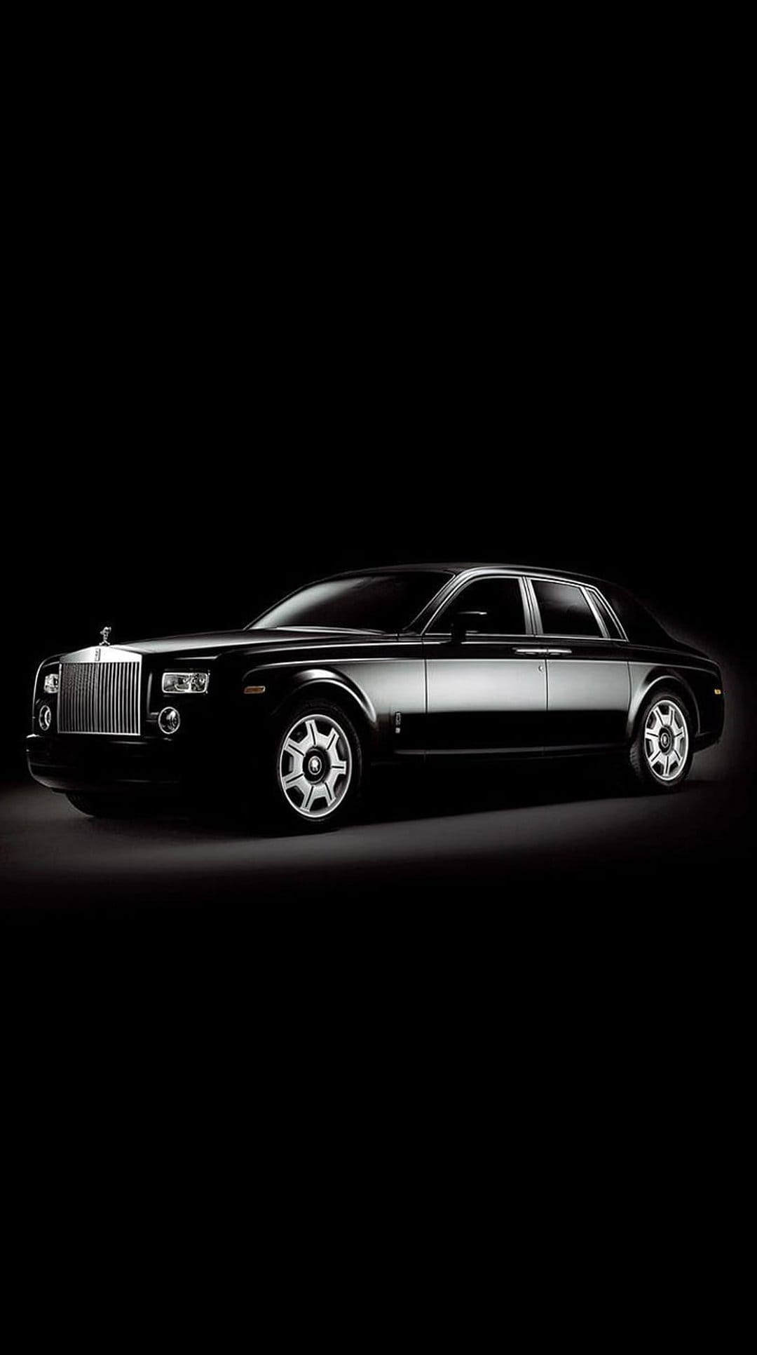Rolls-Royce Phantom sedan with a glowing grille and chrome accents against a solid black background.