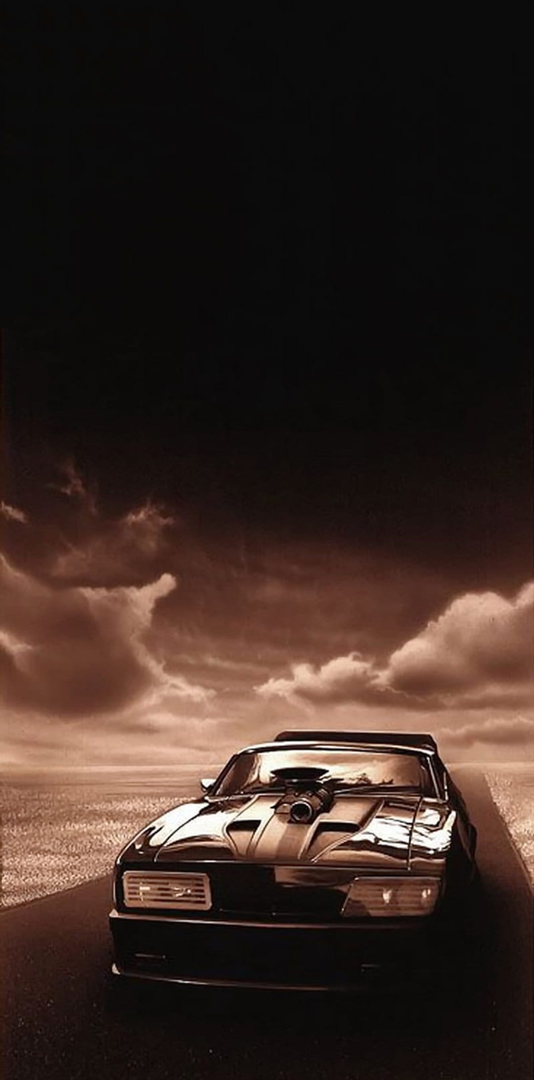 Black muscle car with a large supercharger sits on a cracked road beneath a heavy, sepia-tinted cloudy sky.