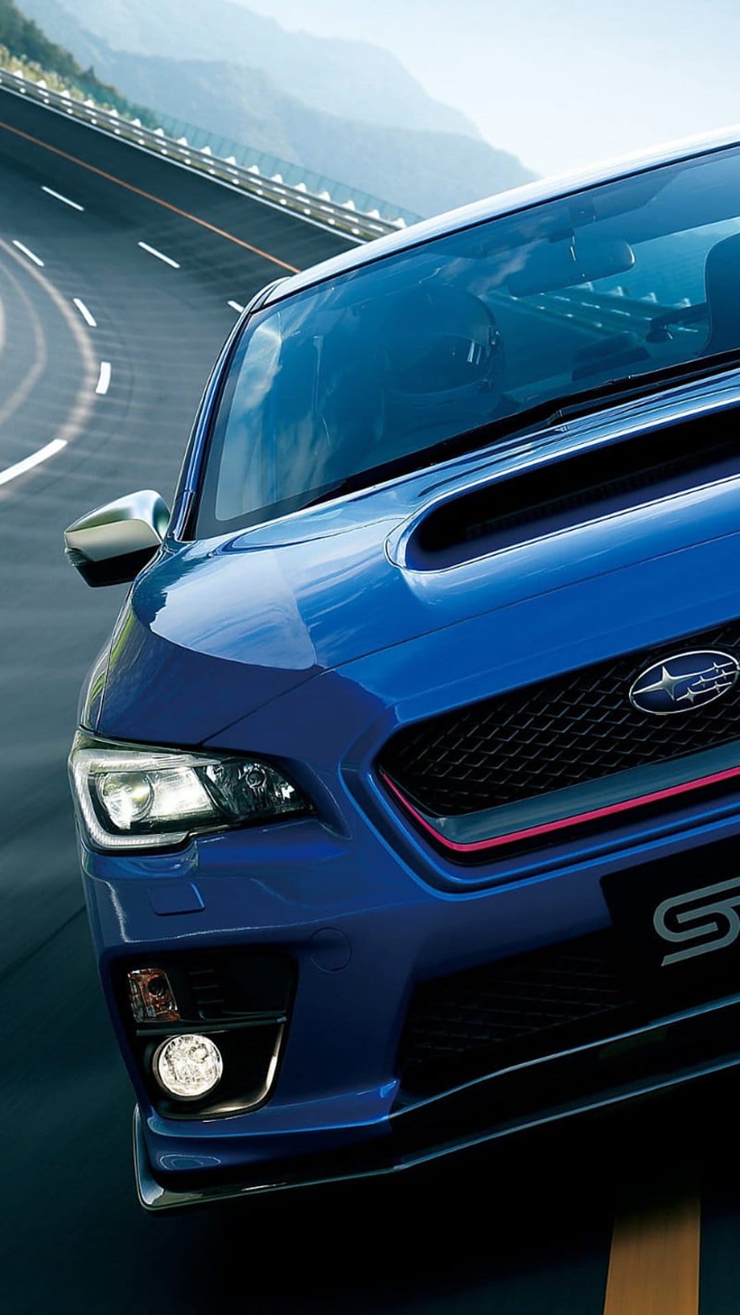 Blue Subaru WRX STI driving on a winding asphalt road through misty green mountains with a cinematic atmosphere.