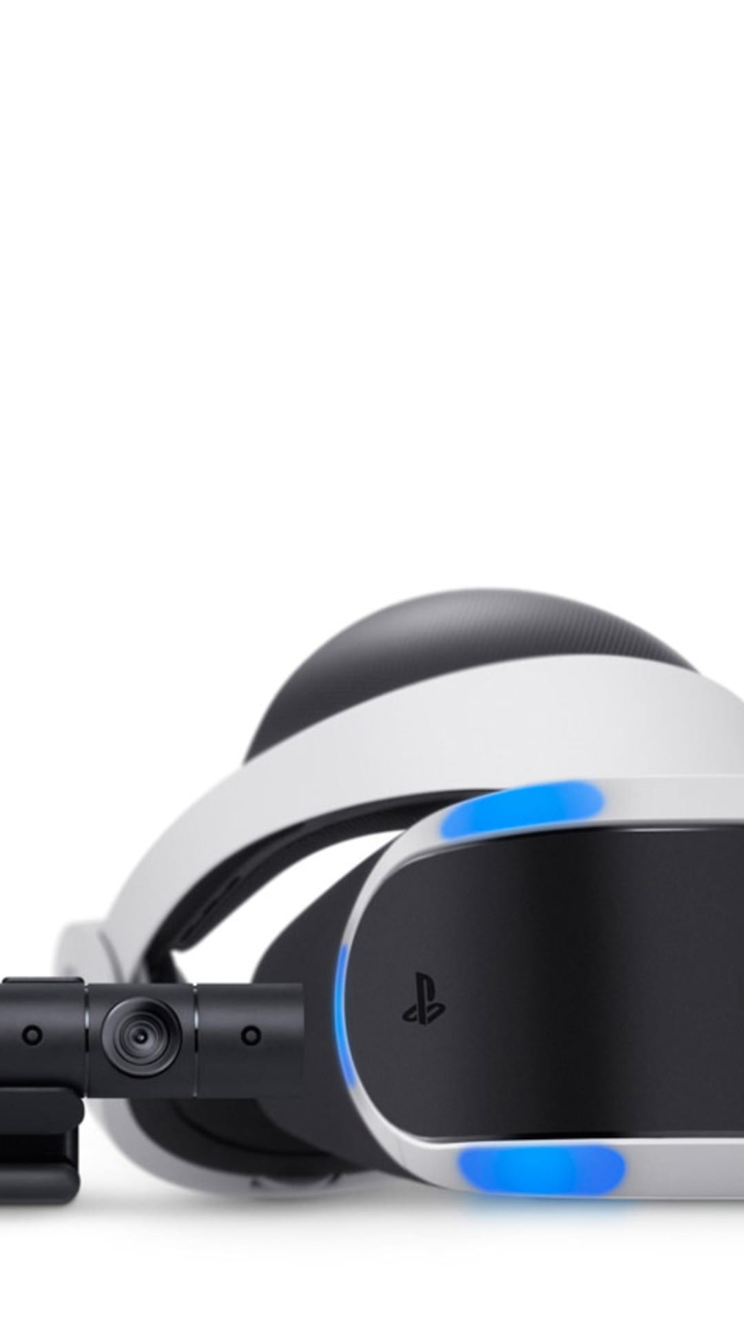PlayStation VR headset with glowing blue LEDs sits behind its motion camera on a minimalist white surface.