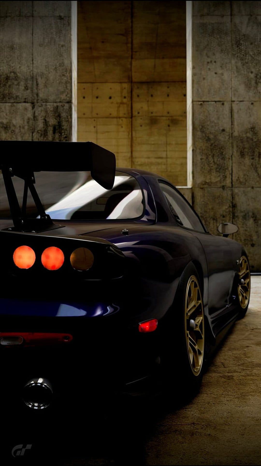Mazda RX-7 FD rear view with glowing orange taillights and gold wheels against a concrete wall.