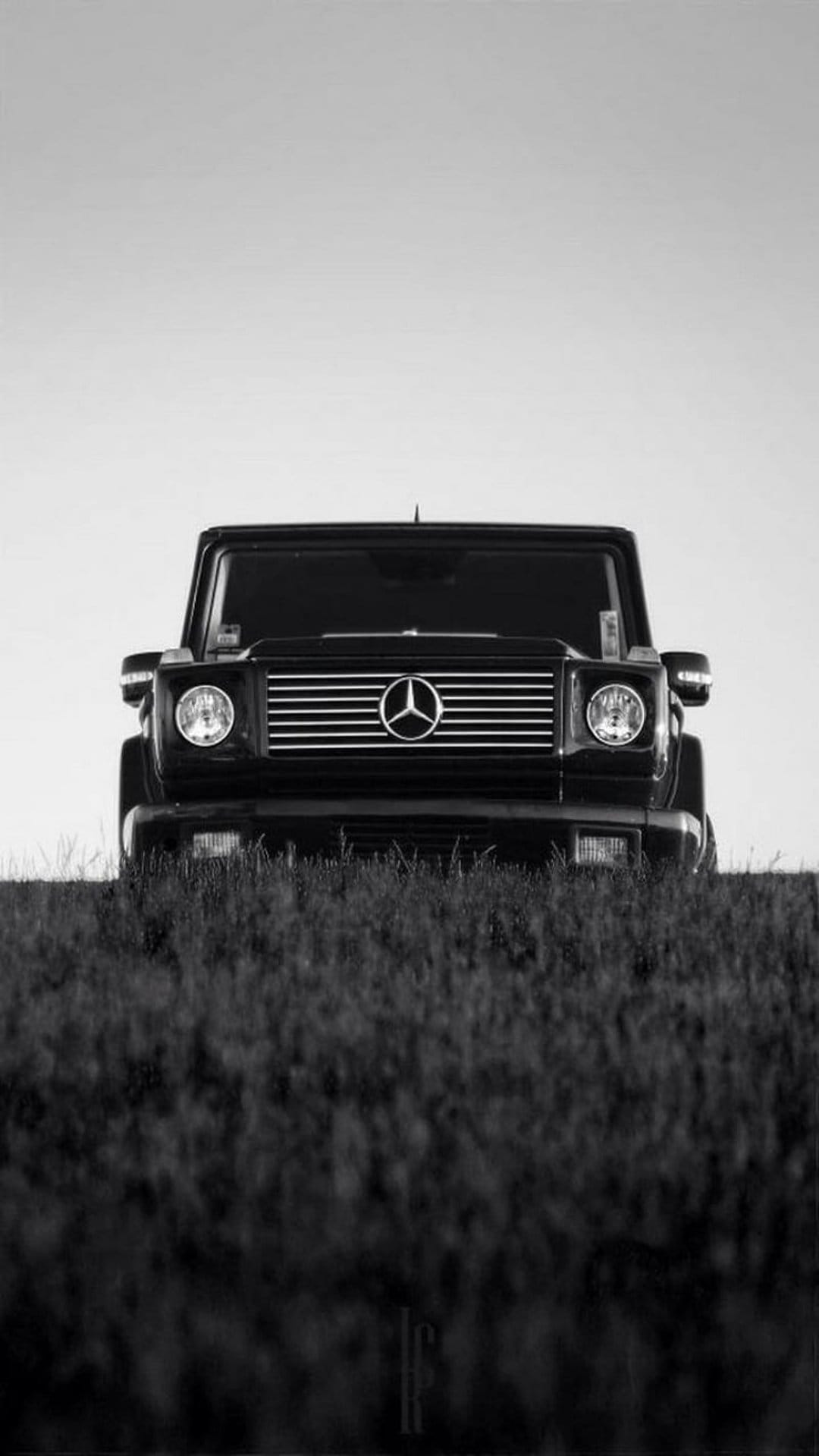 Mercedes-Benz G-Wagon SUV parked in a grassy field, captured in high-contrast black and white monochrome tones.
