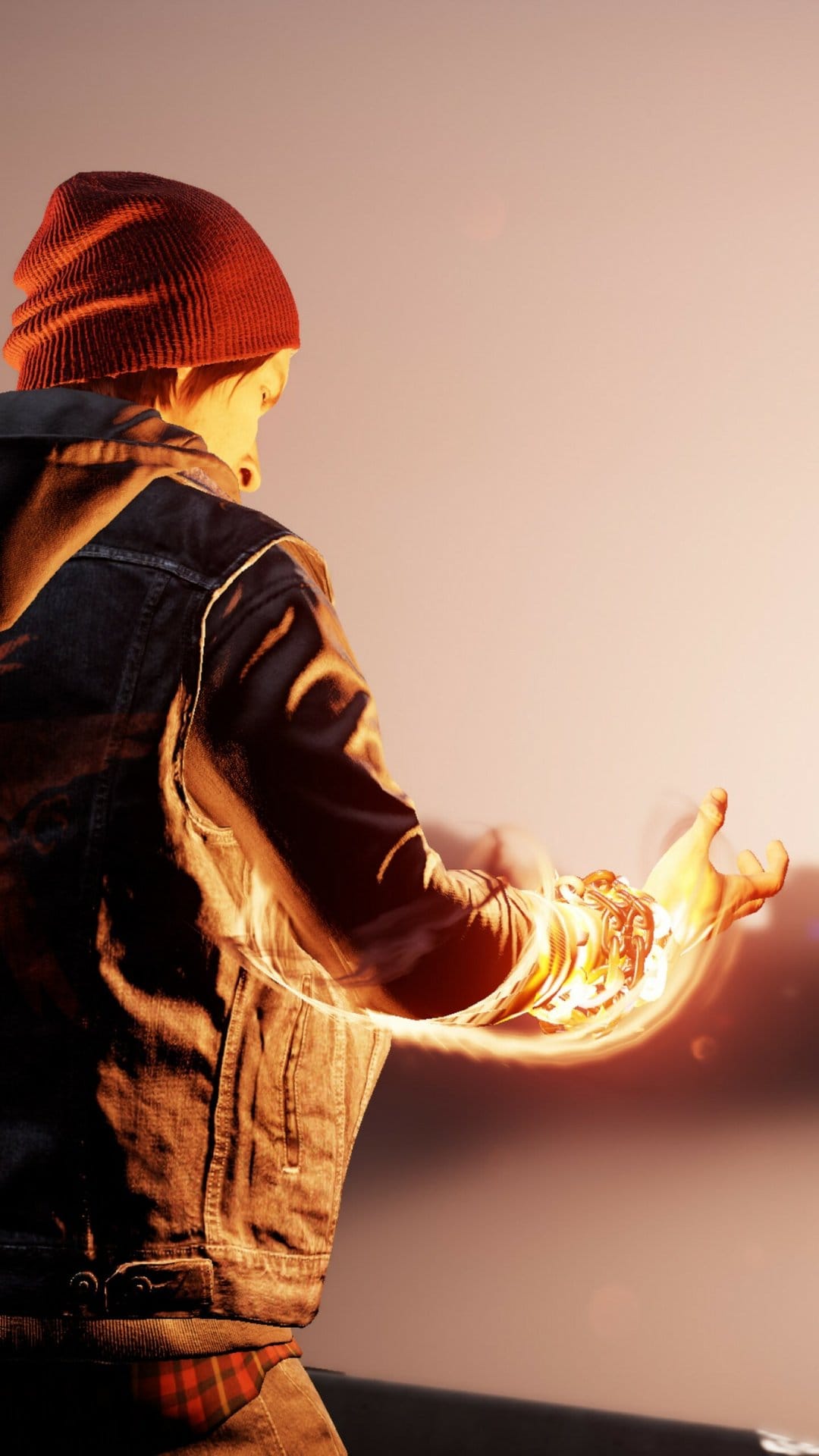 Delsin Rowe with glowing orange smoke powers on his arm wearing a red beanie and denim vest.