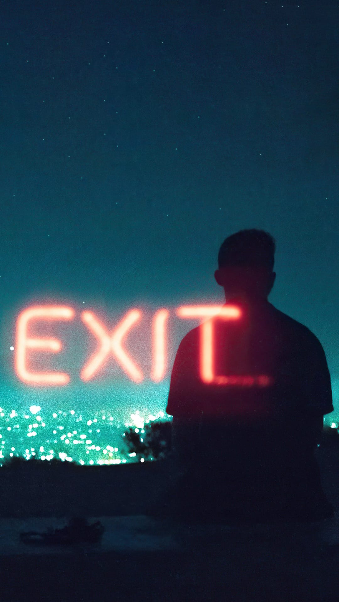 Red neon EXIT sign glowing next to a person's silhouette against a starry night sky and distant city lights.
