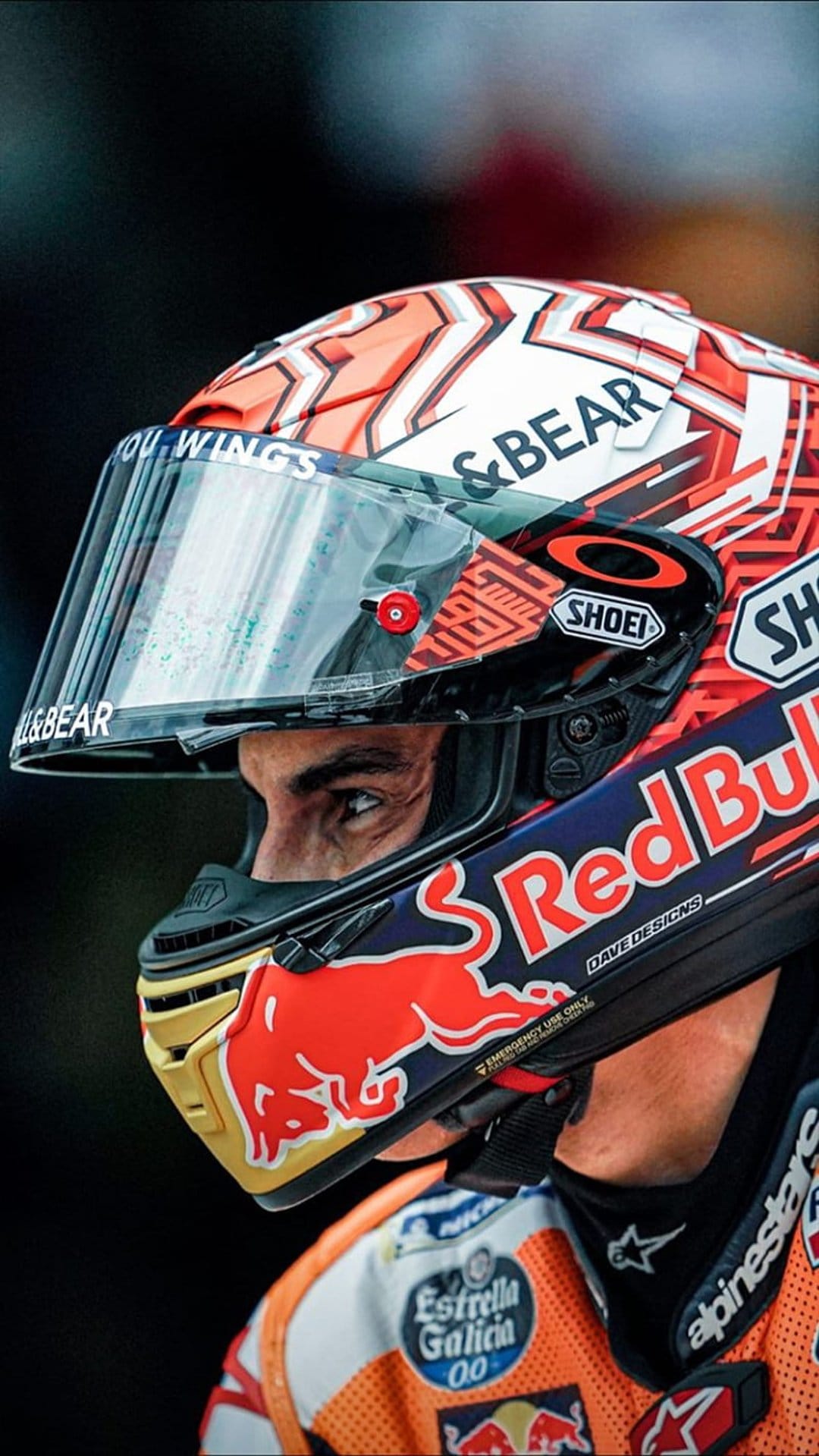Motorcyclist wearing a Shoei helmet and Alpinestars suit stares forward with intense focus in a close-up portrait.
