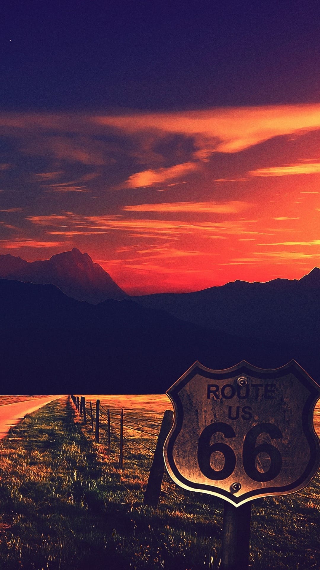 Weathered Route 66 sign stands by a long desert highway under a vivid orange and purple sunset sky.
