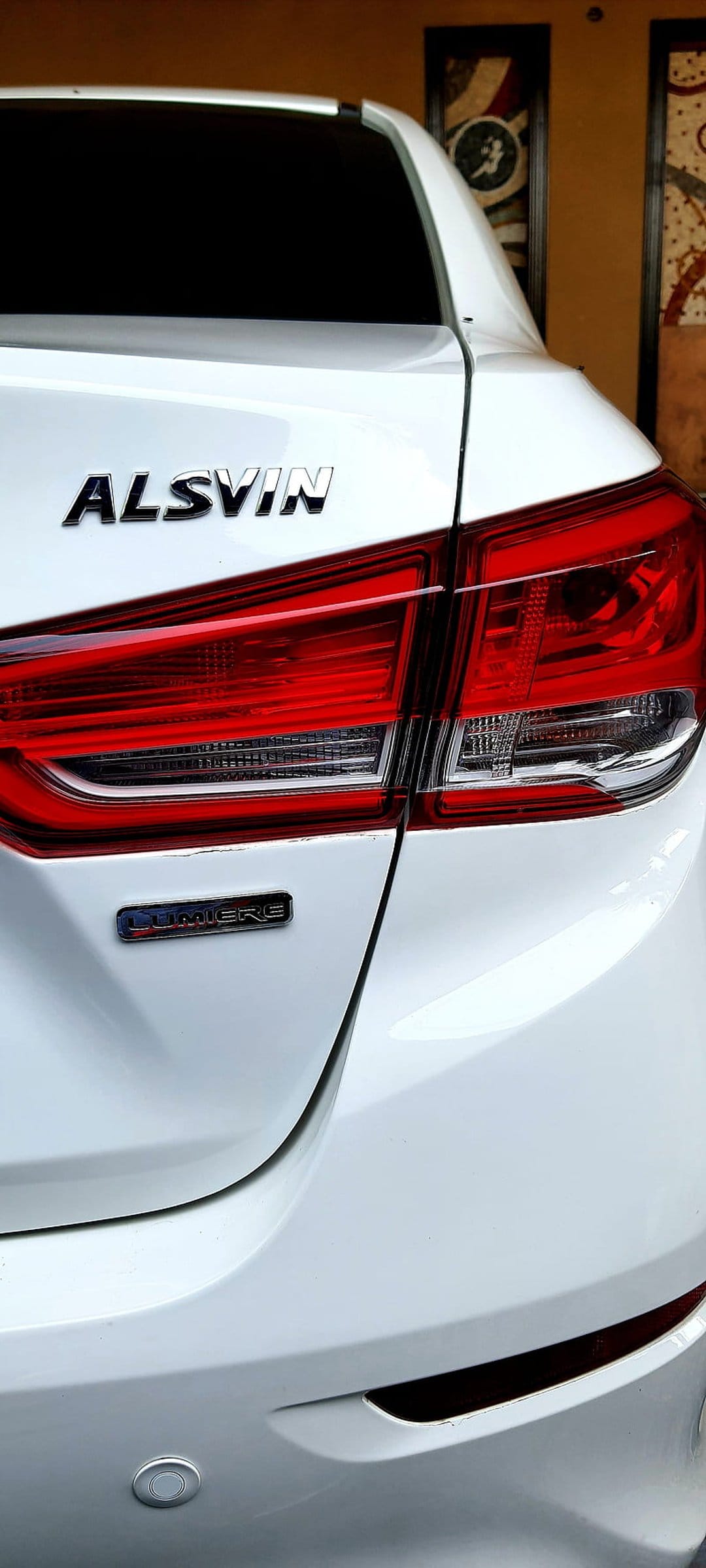 White Alsvin sedan trunk lid featuring a chrome badge and detailed red LED taillights in a close-up rear view.
