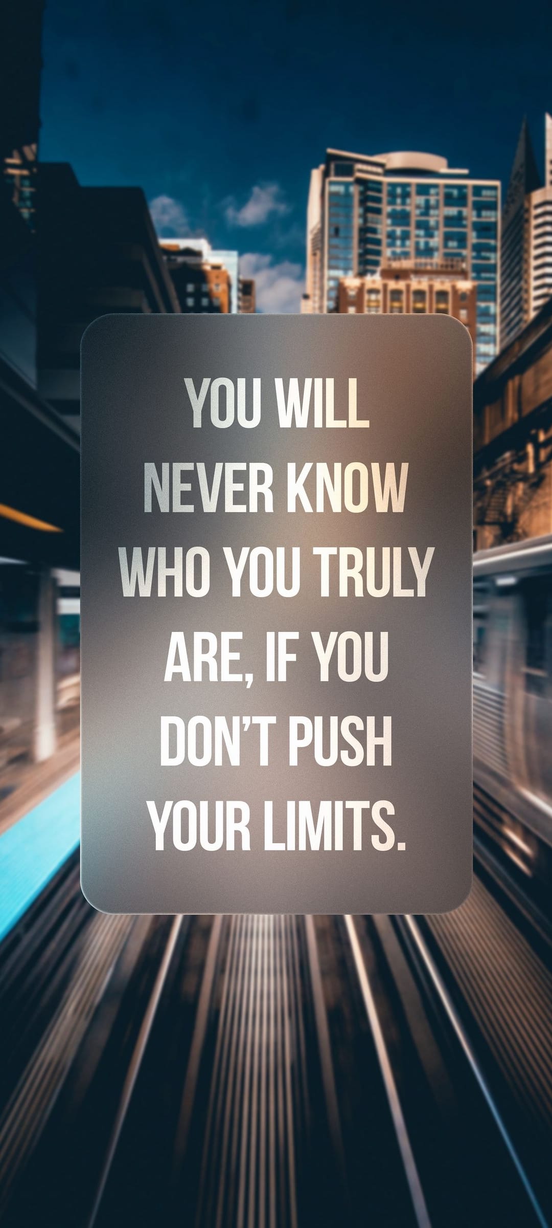 Gray placard with motivational text centered over a blurred urban background with bokeh lights in vertical view.