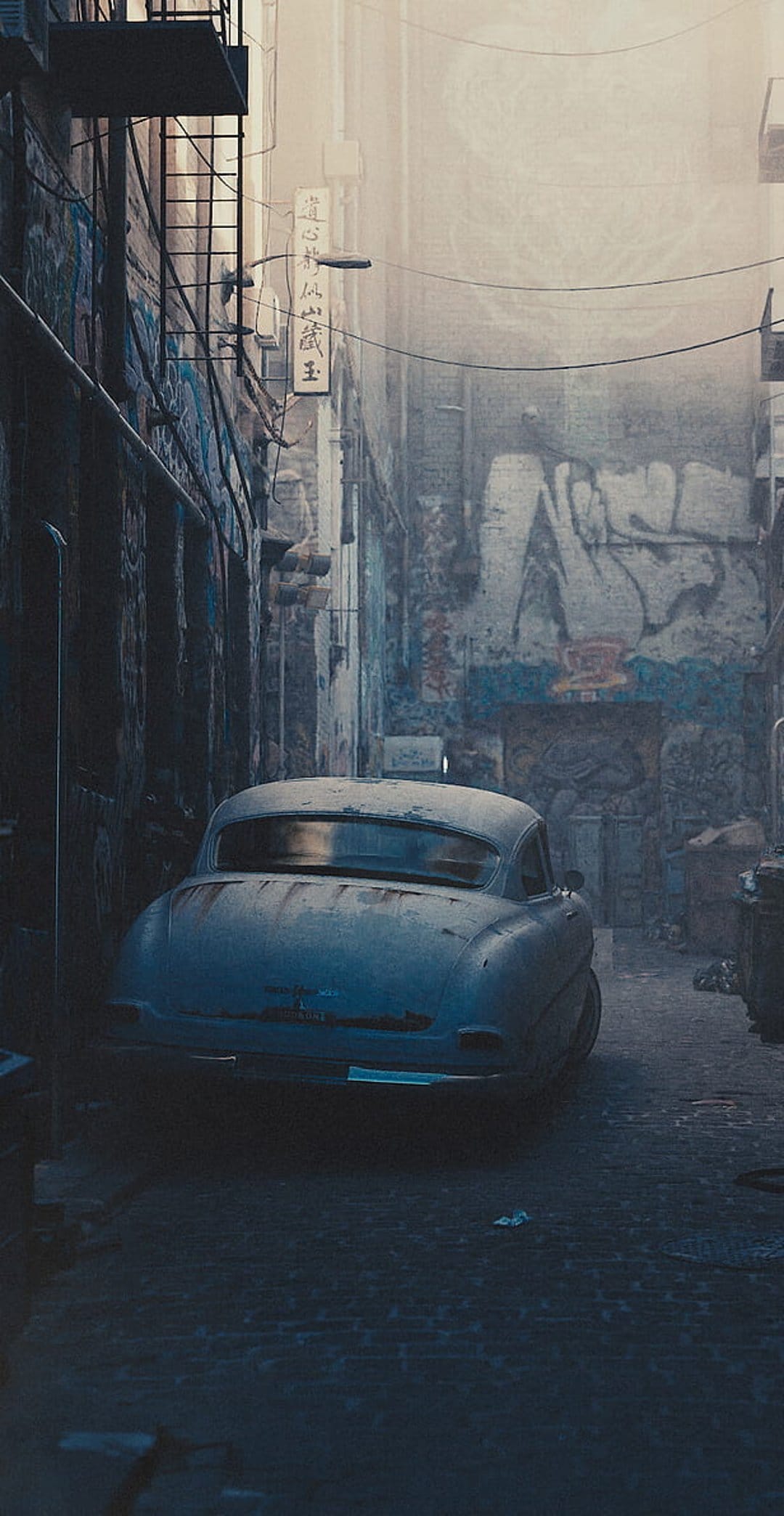 Vintage blue car parked in a dark alleyway surrounded by colorful graffiti and a metal fire escape.