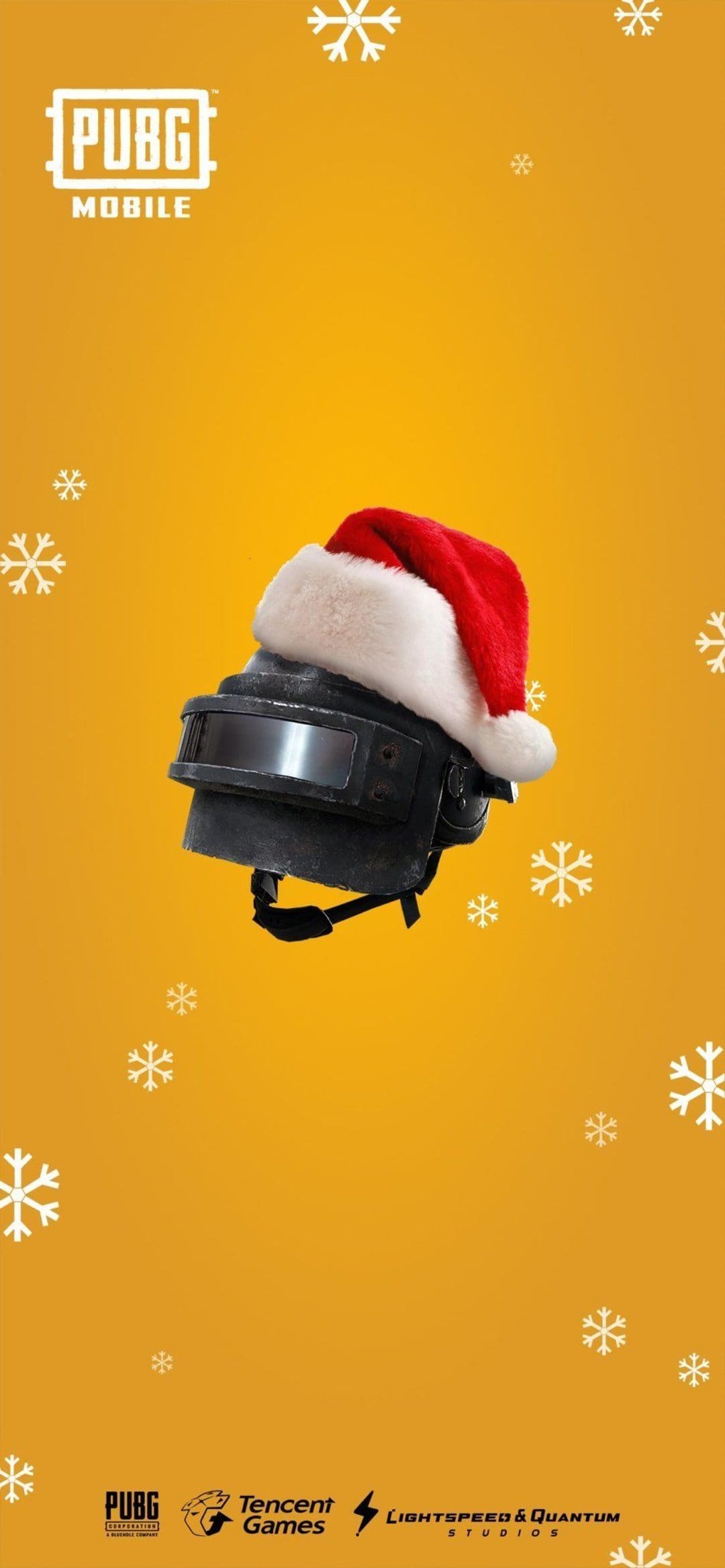 Black battle royale helmet with a red Santa hat on an orange background with falling white snowflakes.