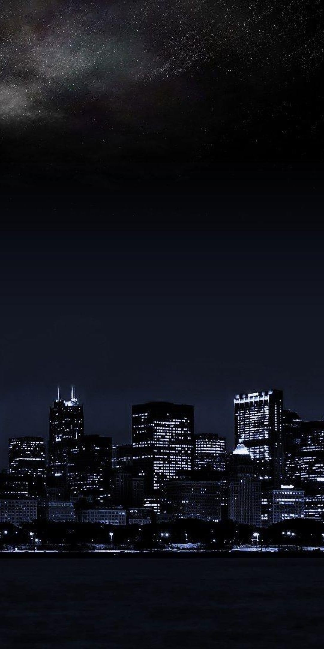 Chicago skyline silhouettes with glowing windows under a starry night sky and visible Milky Way galaxy.