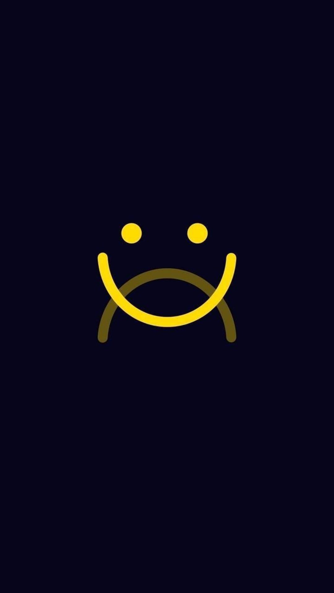 Yellow smiley face with two mouths showing happy and sad expressions centered on a solid black background.