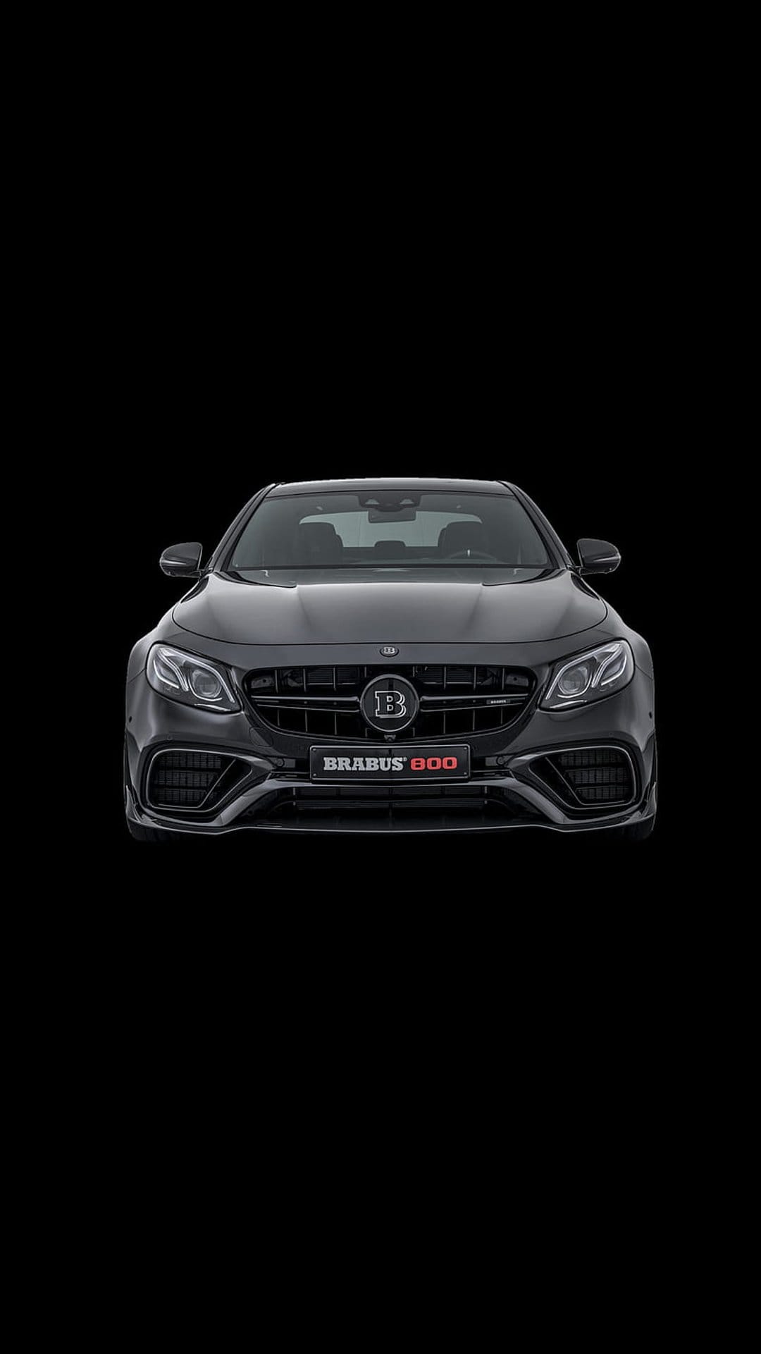 Brabus 800 sedan front end featuring a large B emblem on the grille and sharp LED headlights in a dark setting.