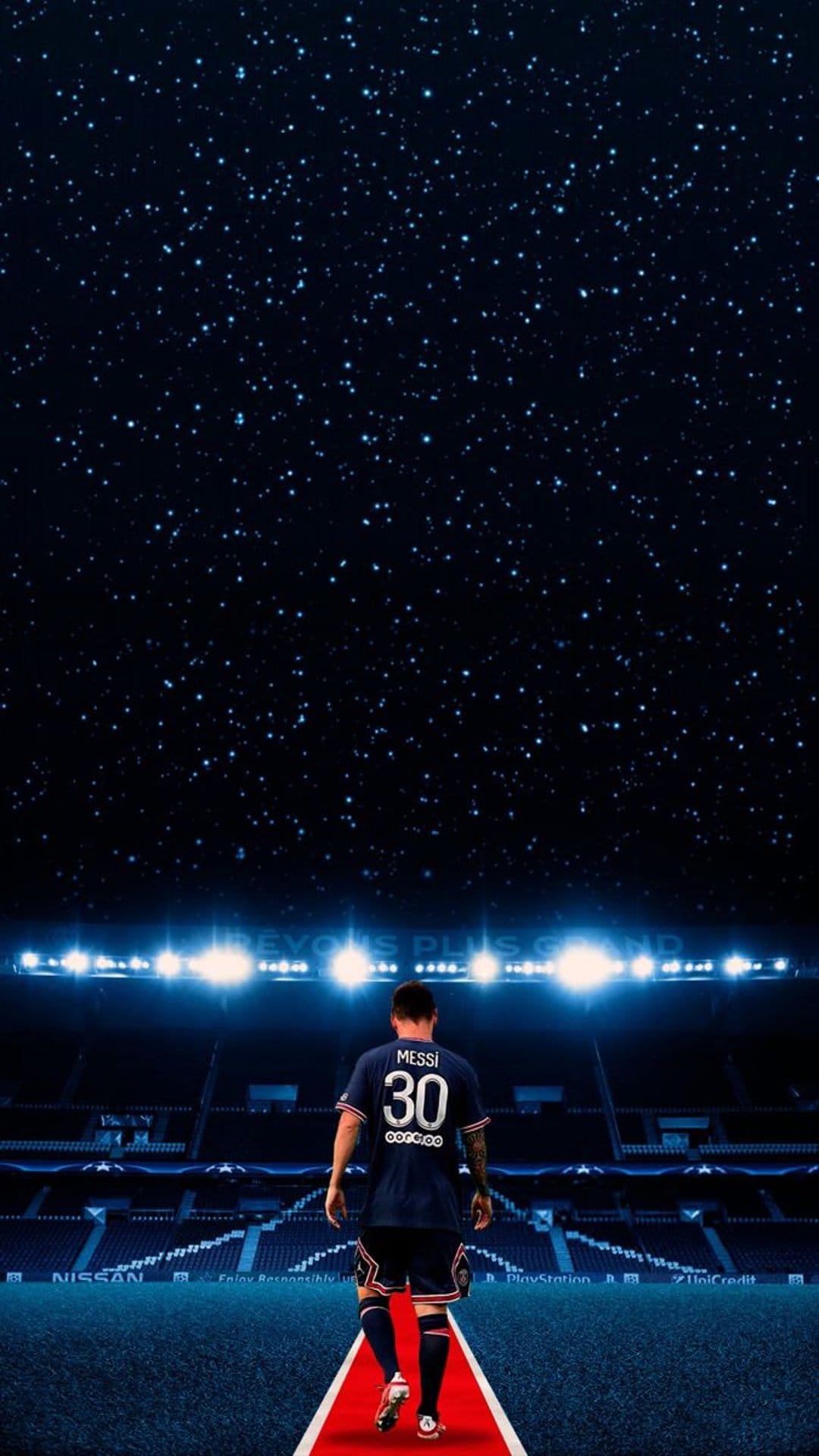 Lionel Messi in a number 30 jersey walks toward a glowing stadium under a starry night sky on a red carpet.