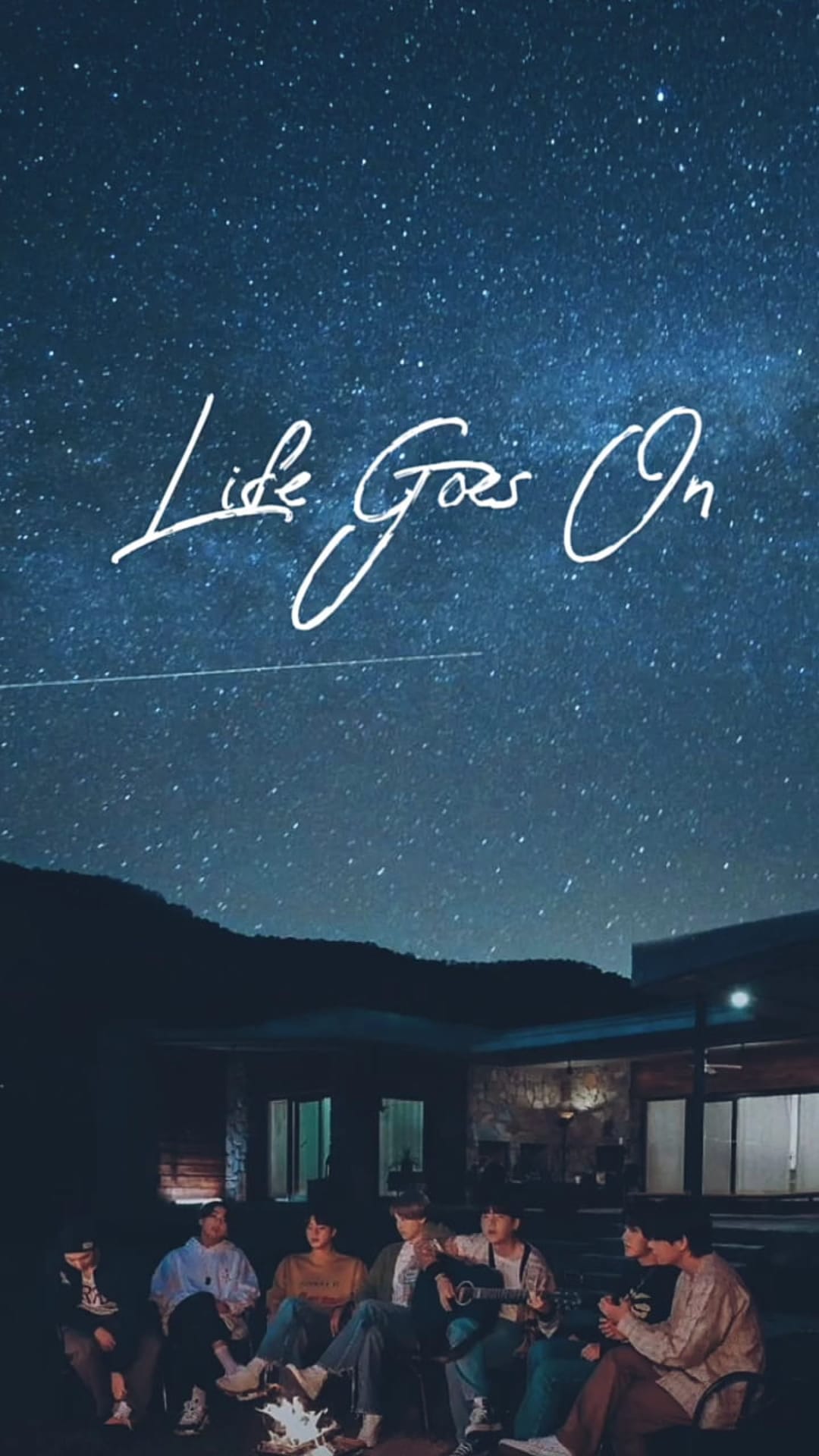 BTS members sit around a glowing campfire under a starry night sky with script text reading Life Goes On.