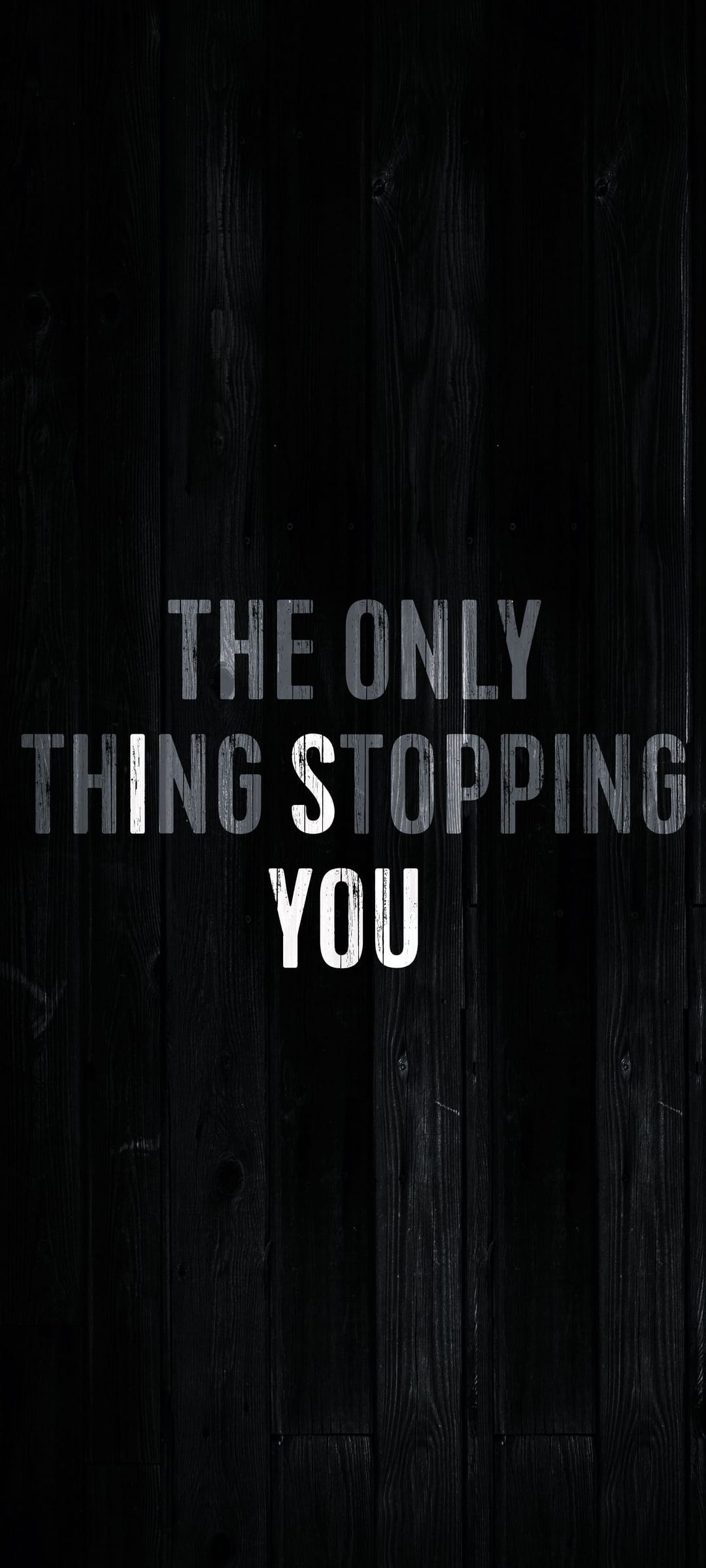 Distressed white block lettering on dark brown wooden planks displays an inspirational self-empowerment message.