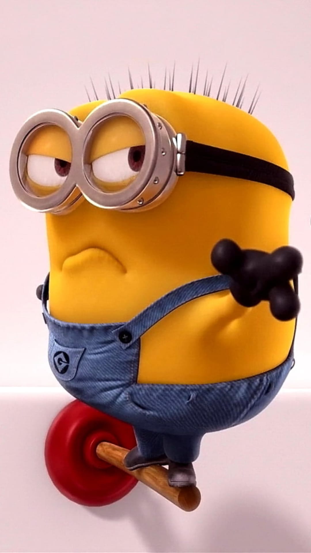 Yellow minion with a grumpy face and goggles balances atop a red plunger while wearing blue denim overalls.
