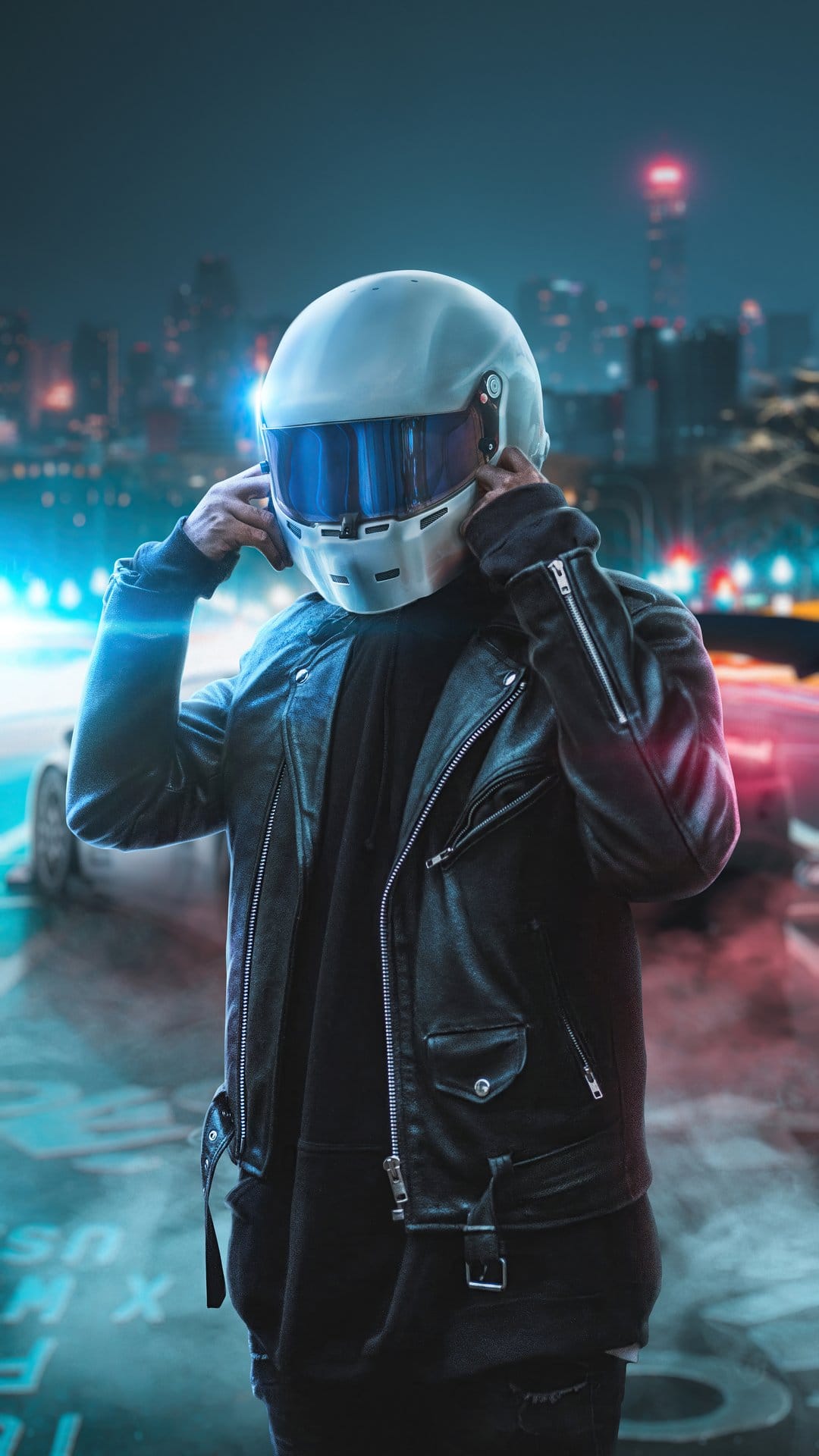 Man in a white helmet and black leather jacket stands before blurred neon city lights and a car at night.
