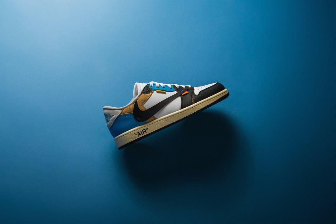 Off-White Nike Air Jordan 1 Low midsole with AIR text, blue leather, and a red zip tie on the laces.