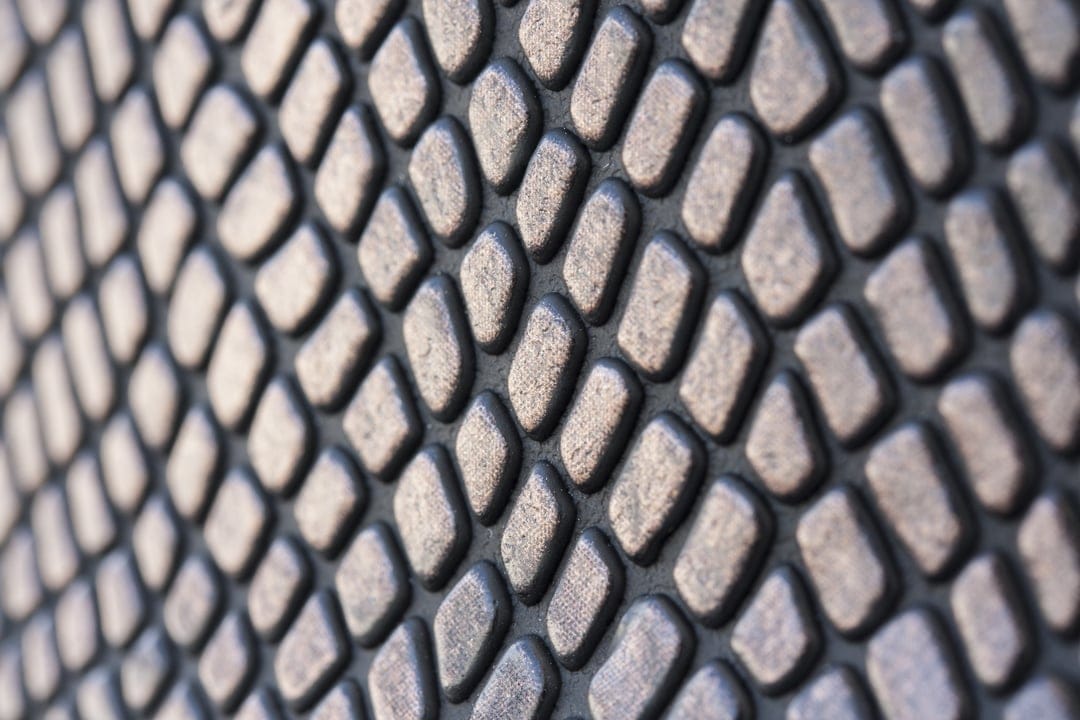 Staggered dark grey oval nodules create a repetitive tactile texture with soft highlights and deep shadows.