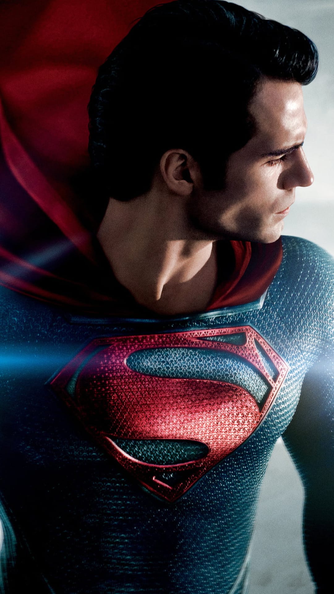 Henry Cavill as Superman wears his textured blue suit and red crest against a dark cinematic background.
