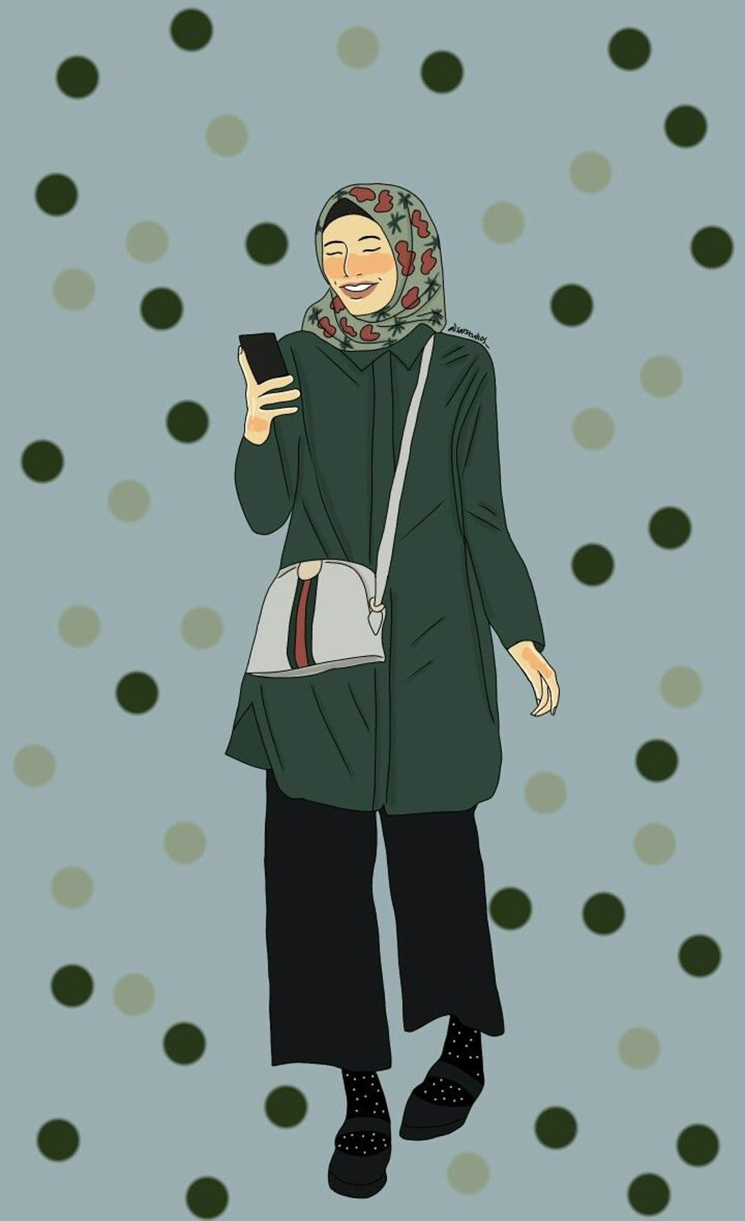 Woman in a floral hijab and green tunic smiles at her phone while wearing polka dot socks and Mary Jane shoes.
