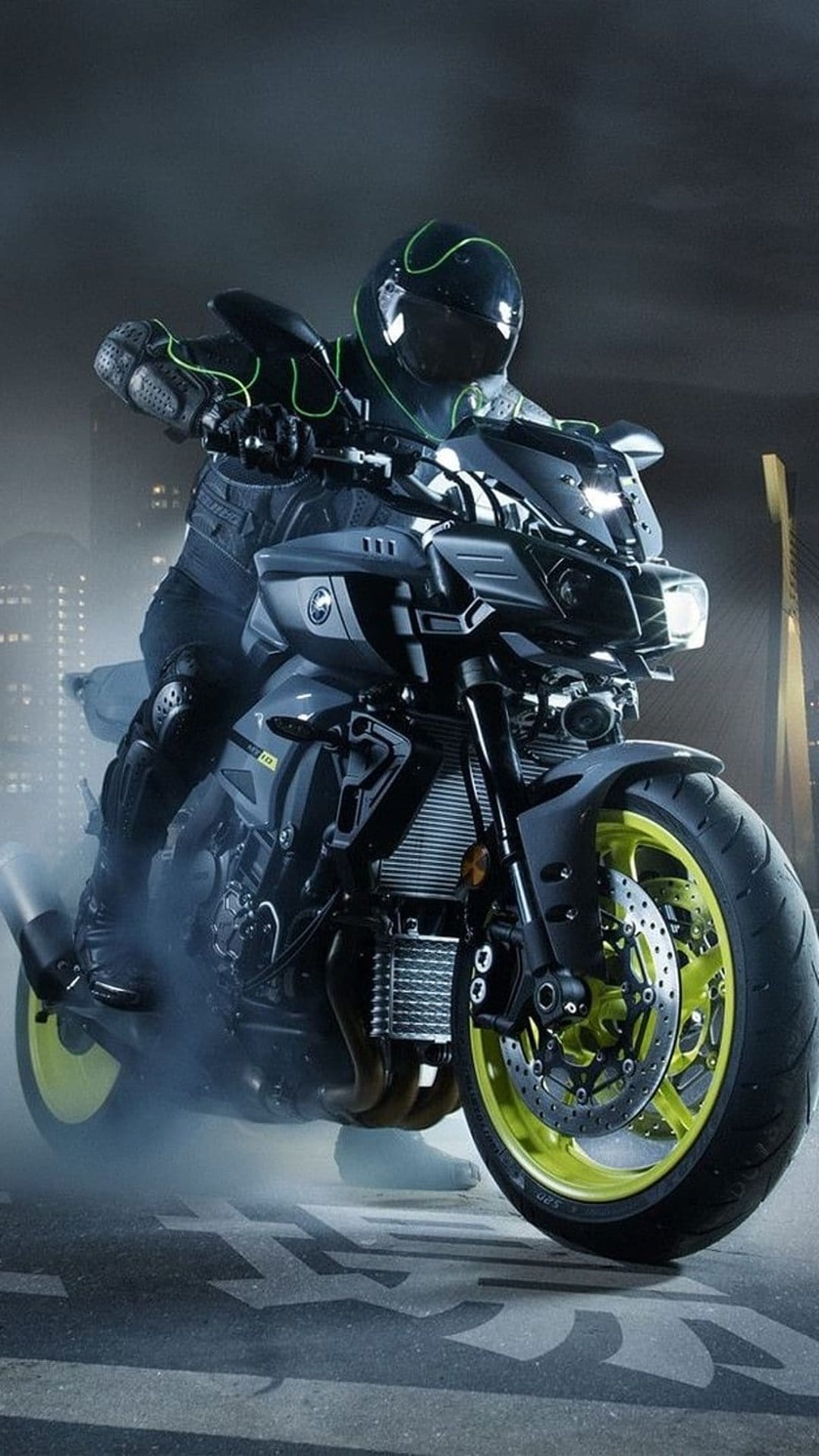 Yamaha motorcycle rider with glowing yellow rims maneuvers through a smoky urban street at night with neon bokeh.
