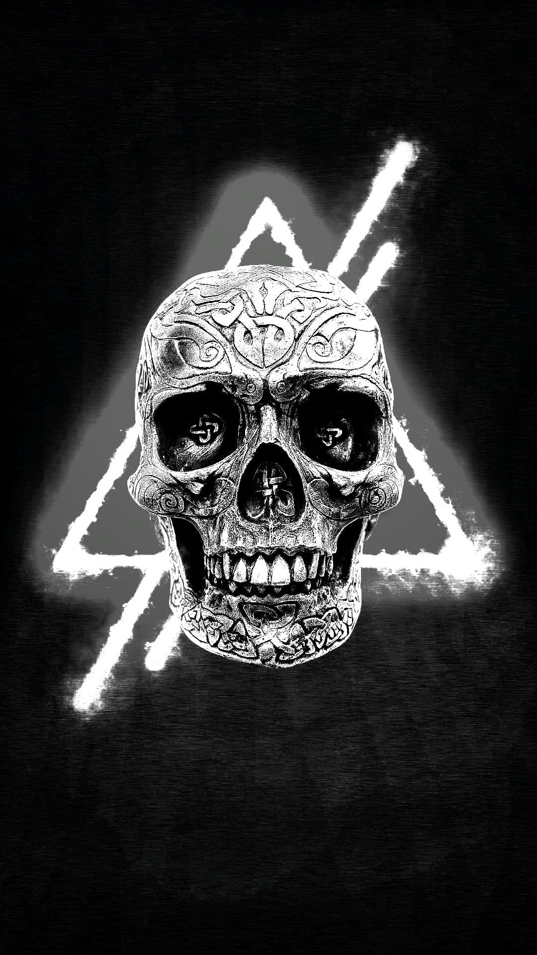 Ornate skull with intricate engravings positioned in front of a glowing neon blue triangle on a black background.