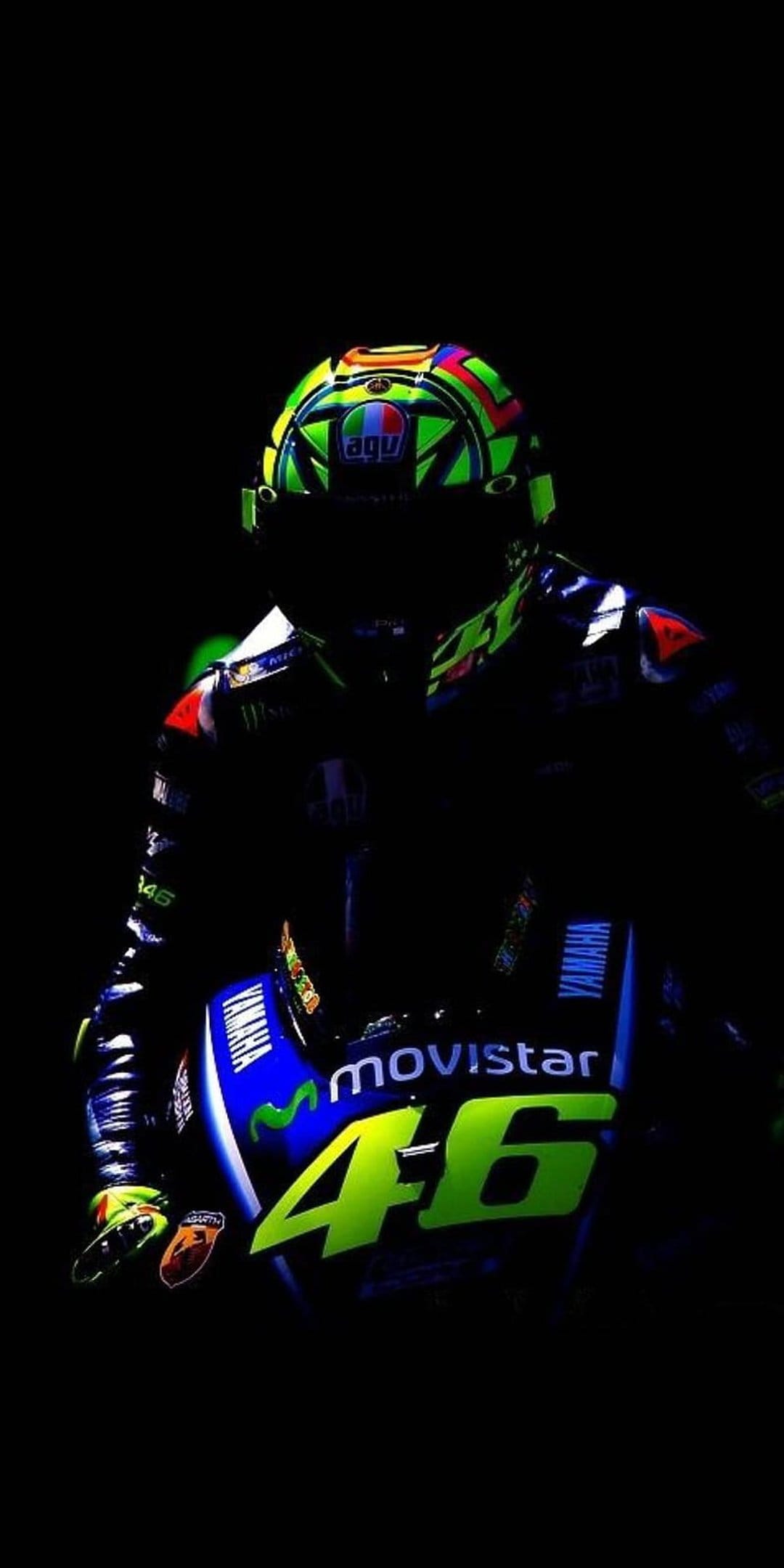 Valentino Rossi AGV helmet and Movistar Yamaha motorcycle with number 46 displayed on a dark, moody background.