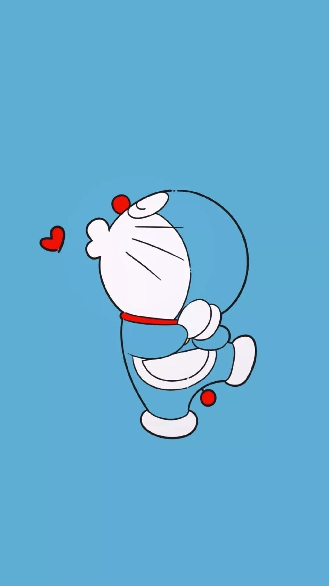 Doraemon in a side profile pose leans back with a raised paw beside two small red hearts on a flat blue background.