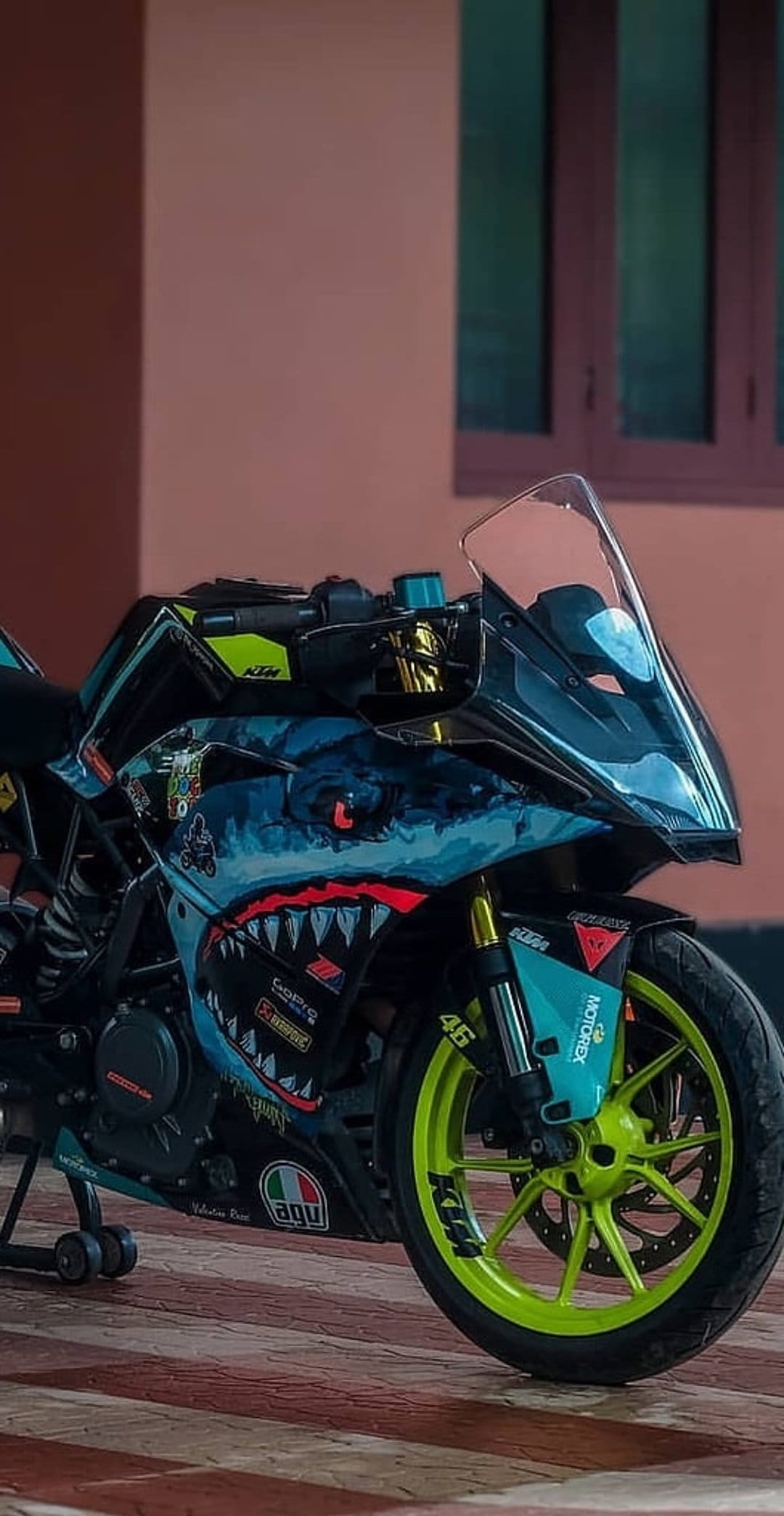KTM RC motorcycle with a shark teeth fairing graphic, blue cloud details, and neon lime green wheels.