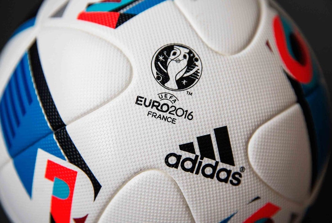 Beau Jeu soccer ball macro features blue and red synthetic panels with the UEFA Euro 2016 tournament logo.