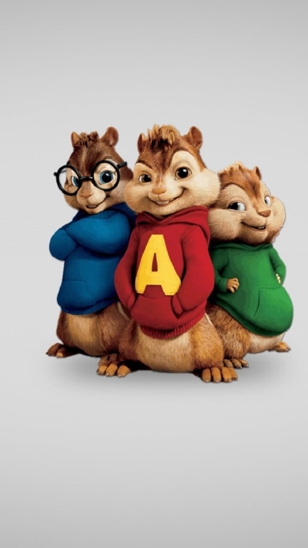 Alvin, Simon, and Theodore the Chipmunks pose in red, blue, and green hoodies against a grey studio backdrop.