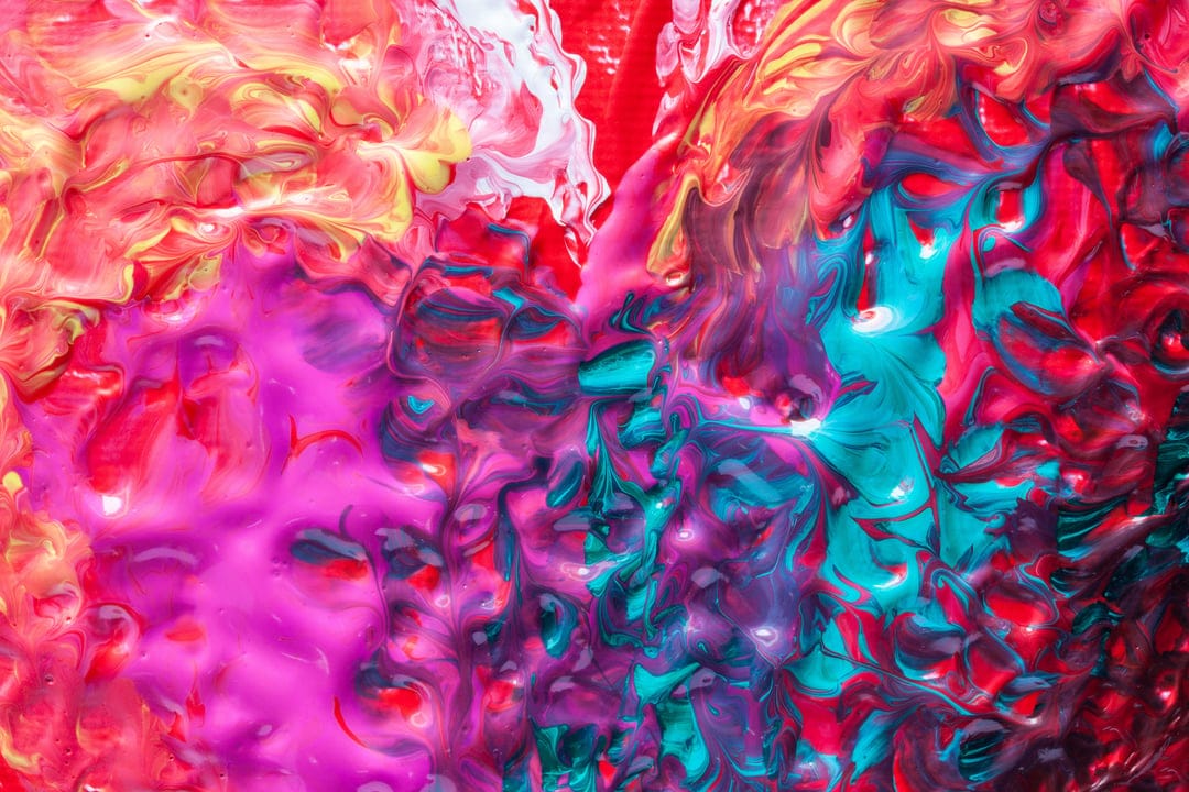 Swirling layers of crimson, turquoise, and magenta paint merge in a textured, glossy fluid composition.