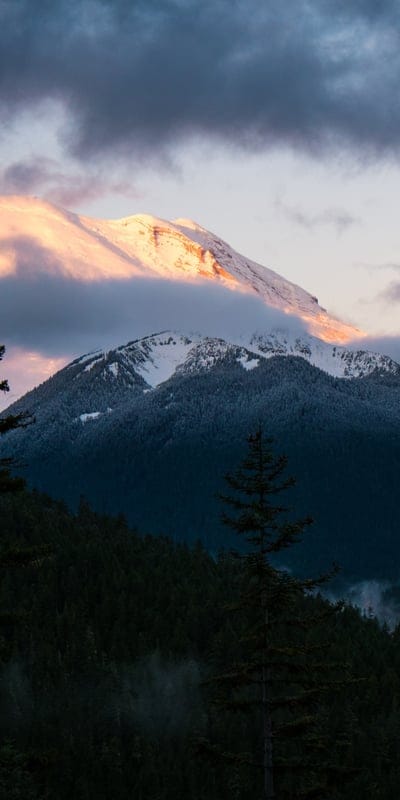 Mount Rainier, national park, Washington, Cascade Range, sunset glow, mountain, forest, snowy peak, clouds, nature, majestic, wilderness, Pacific Northwest, atmospheric, twilight, serene, outdoor, landscape, volcanic, USA