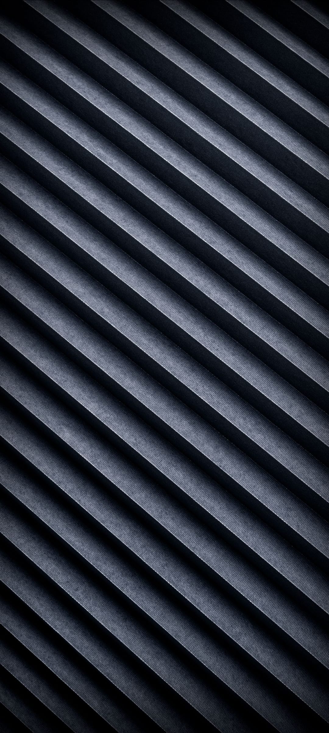 Dark blue pleated folds with diagonal shadows and light highlights create a textured geometric surface pattern.