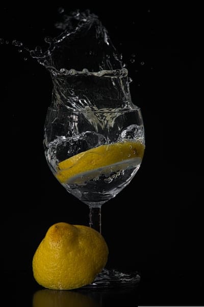 lemon, water, splash, glass, drink, refreshment, citrus, food, beverage, photography, still life, dynamic, motion, dark background, abstract, fresh, liquid, slice, fruit, clear, drinkware, studio lighting, macro