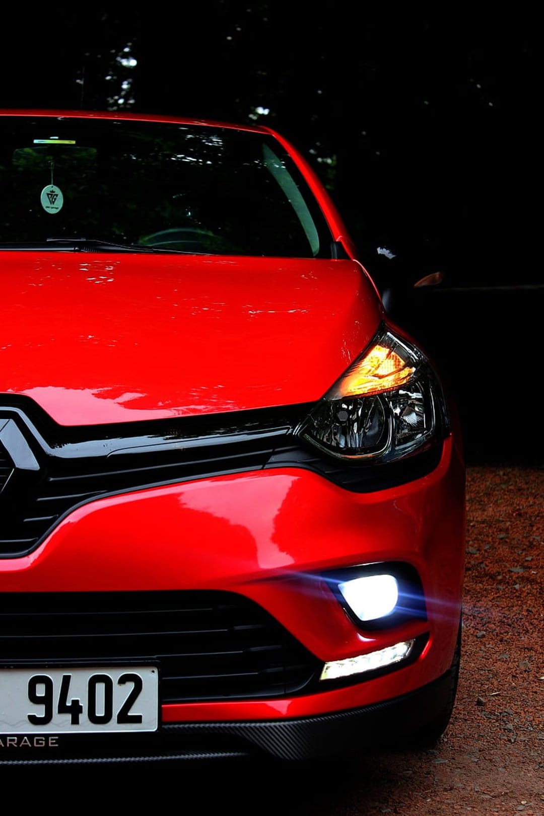 Red Renault Clio facelift front view showing bright LED daytime running lights and a glossy crimson exterior.