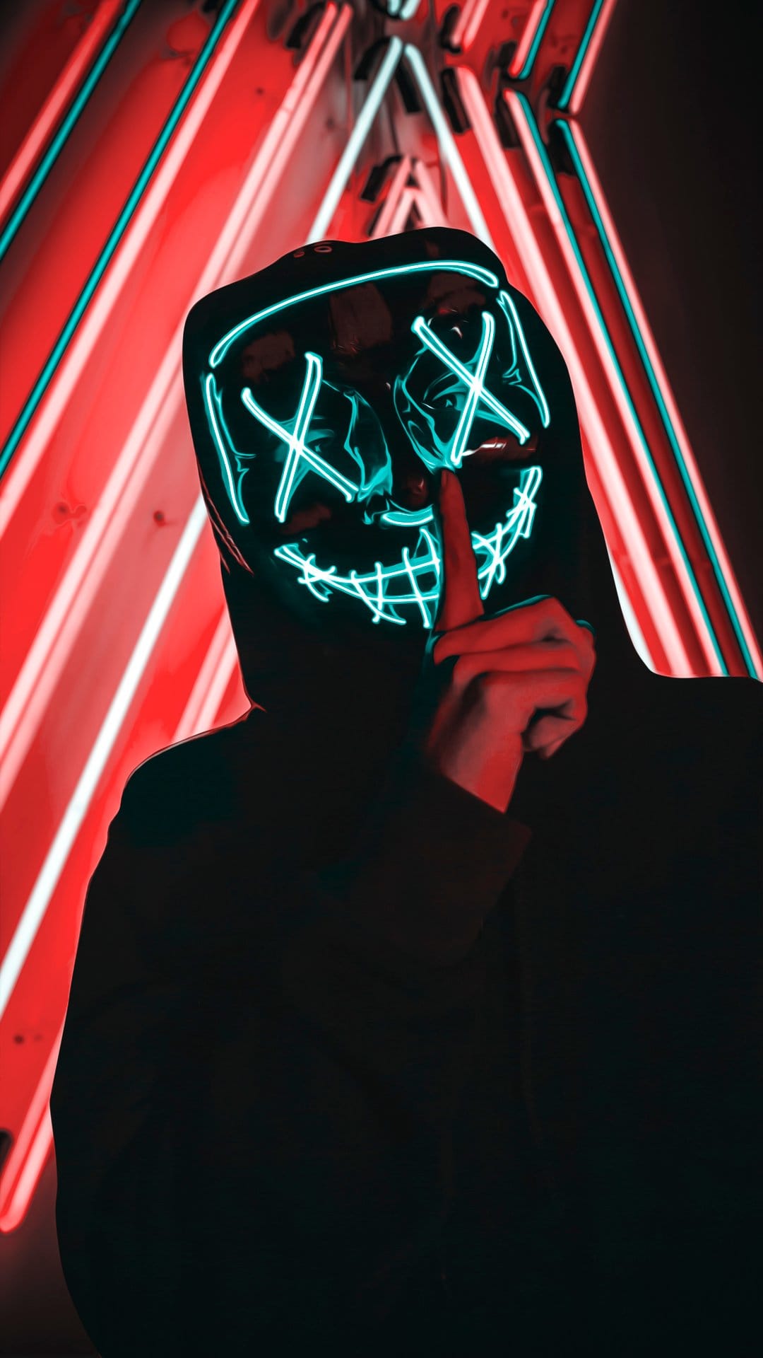 Person in a glowing cyan mask with X eyes holds a finger to their lips against red and white neon background.