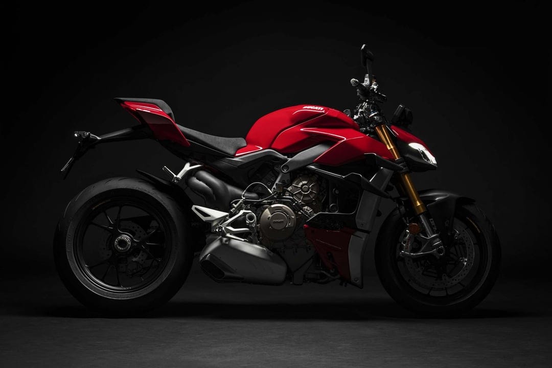 Red Ducati Streetfighter V4 motorcycle in a dark studio profile shot with gold front forks and black background.