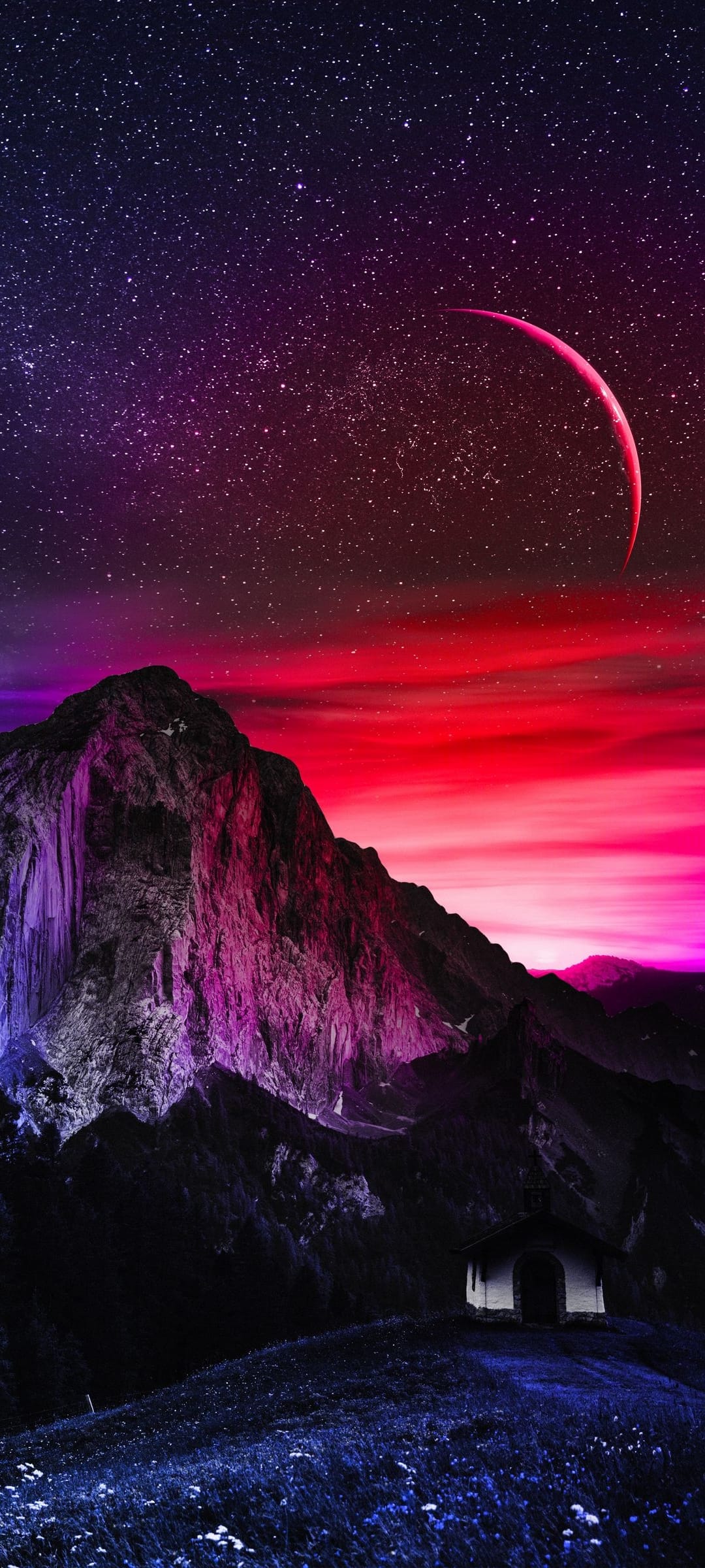 Jagged purple mountains sit beneath a thin red crescent moon and a starry night sky on a dark grassy hill.
