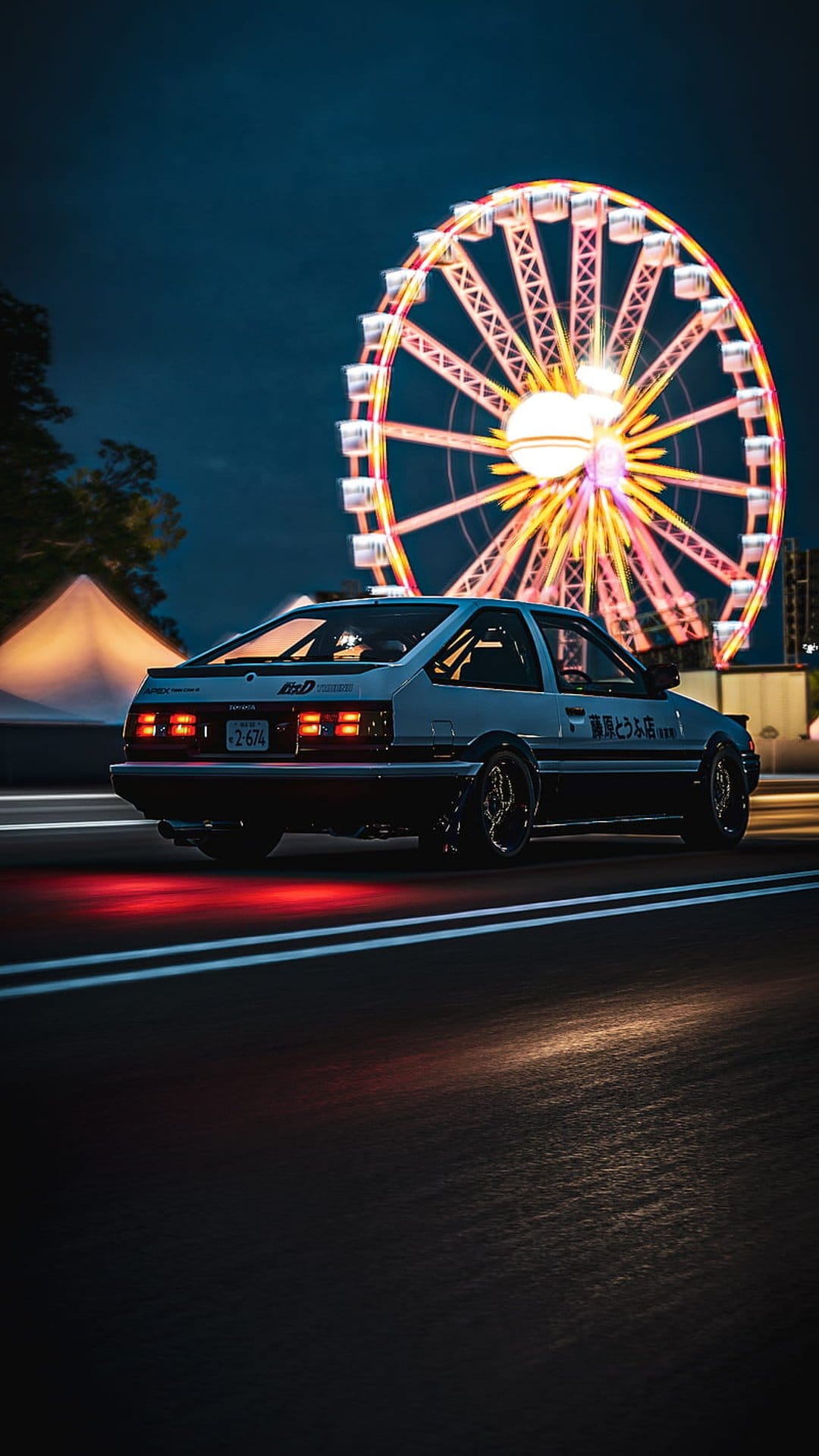 Toyota AE86 speeds along a night road with glowing red taillights past a vibrant, illuminated Ferris wheel.