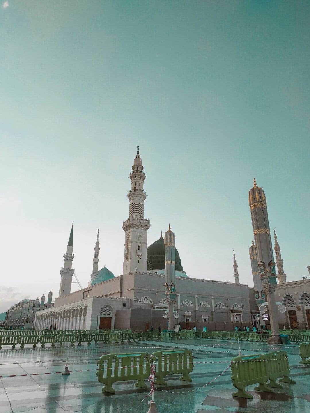 Green Dome and tall white minarets of Al Masjid an Nabawi rise over a vast marble courtyard in Medina.
