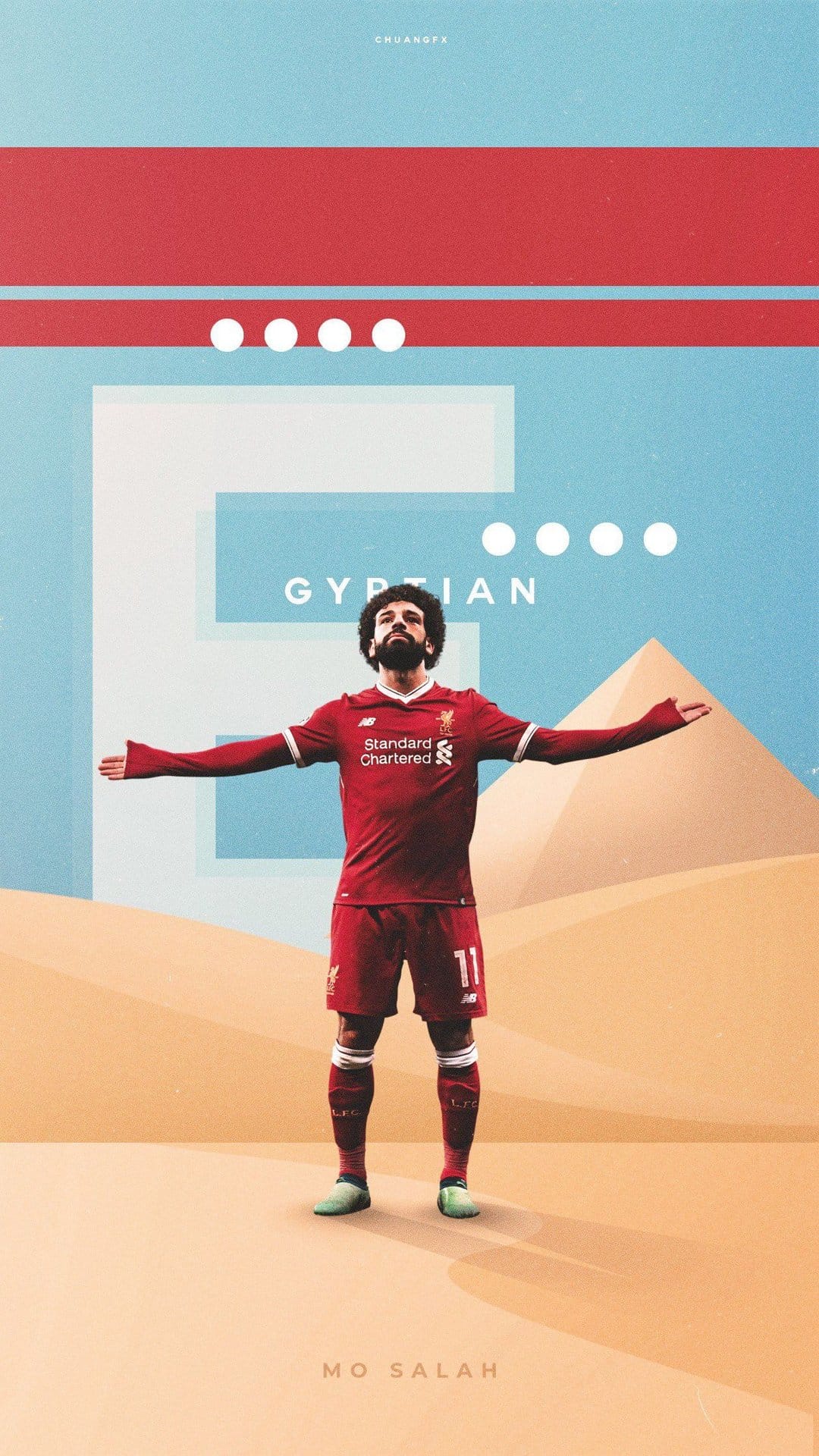 Mohamed Salah wearing a red jersey stands with arms outstretched before pyramids in a golden desert landscape.
