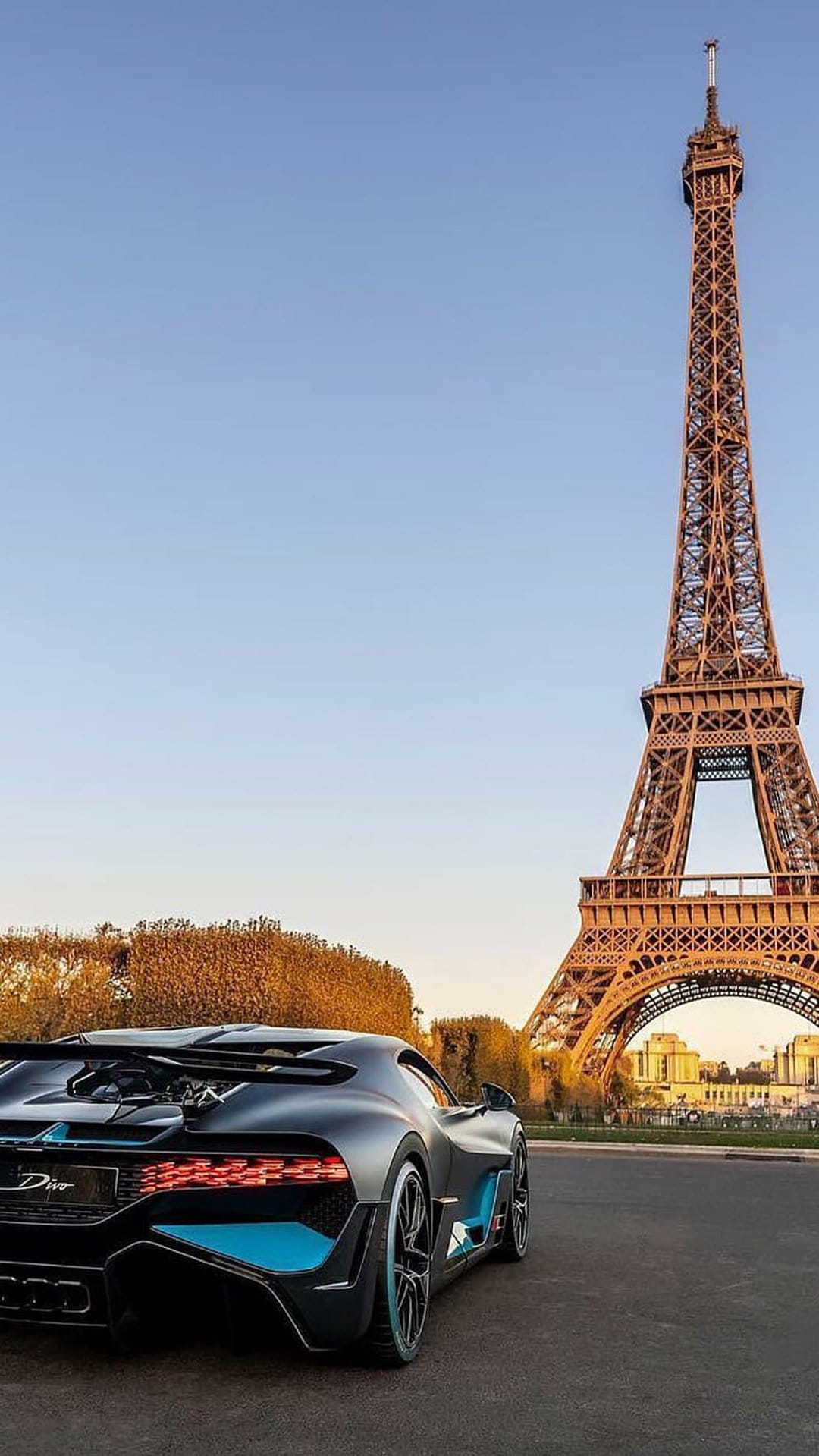 Bugatti Divo hypercar parked on a Parisian street with the Eiffel Tower rising into the sky in the background.