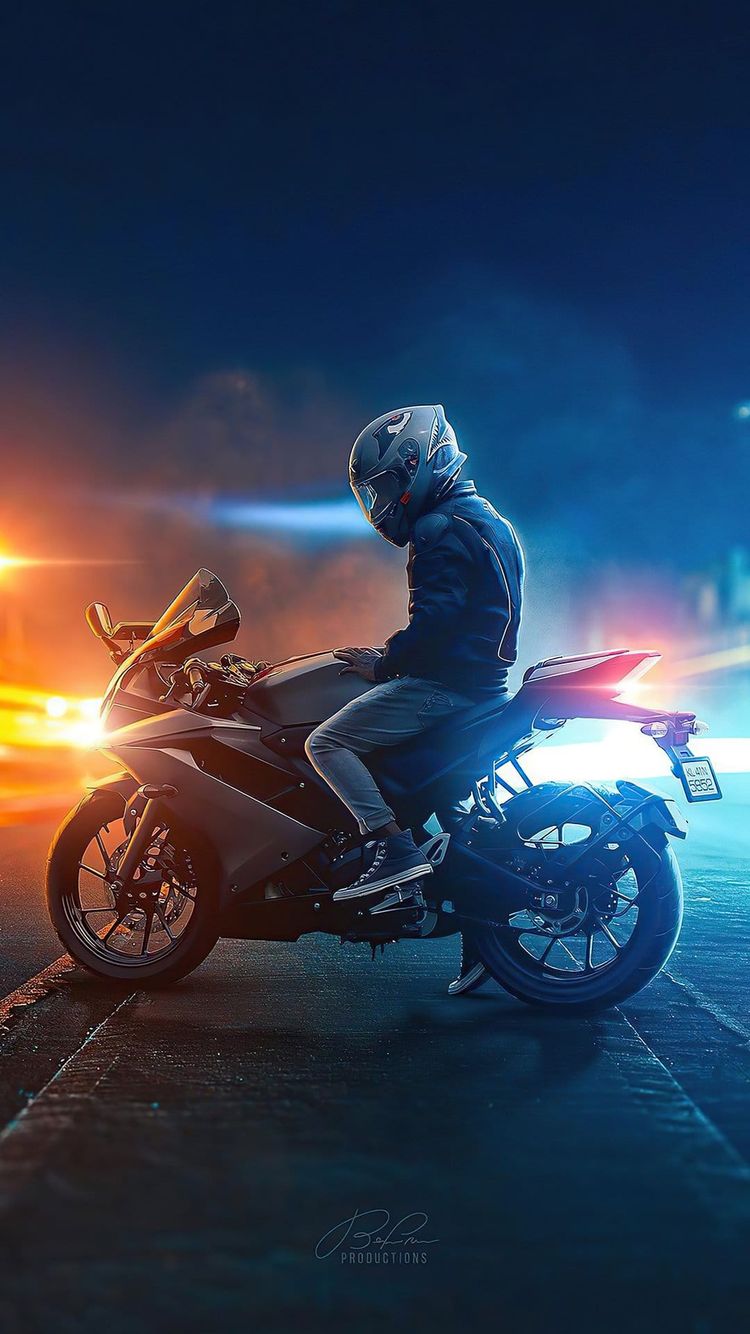 Motorcyclist in full gear on a sportbike at night with orange and blue neon streaks in a blurred city background.